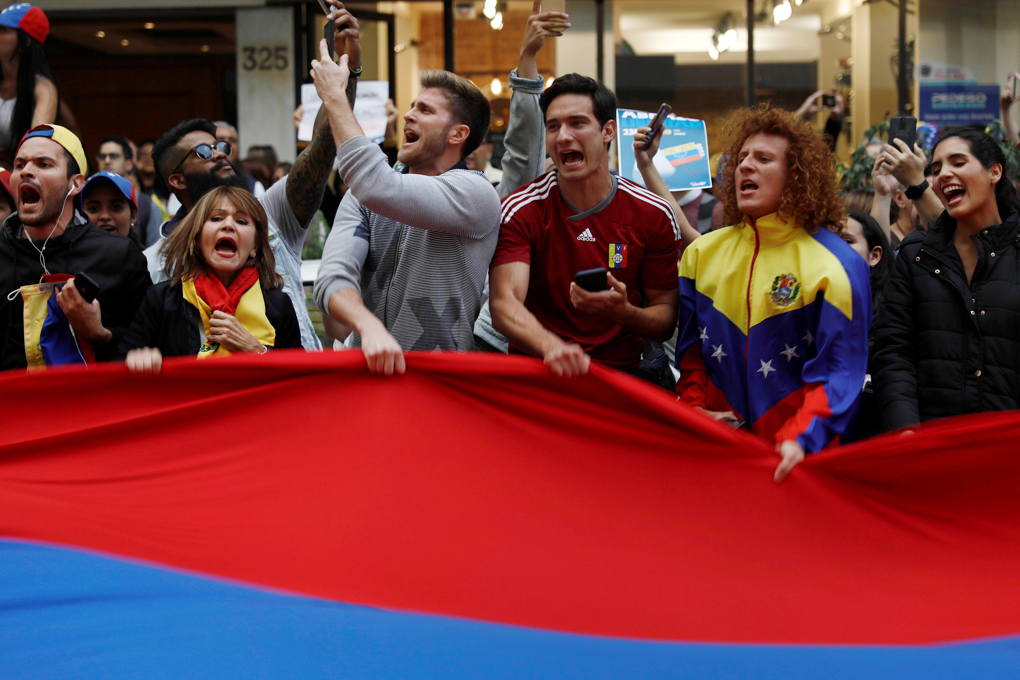 People hold a Venezuelan flag as they gather in support of Venezuela’s opposition leader Juan Guaido outside the Embassy of Venezuela in Mexico City, Mexico January 23, 2019. REUTERS/Edgard Garrido