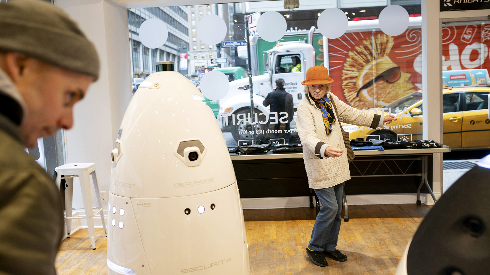 Visitantes interactúan con los robots de seguridad Knightscope (Karsten Moran/The New York Times)