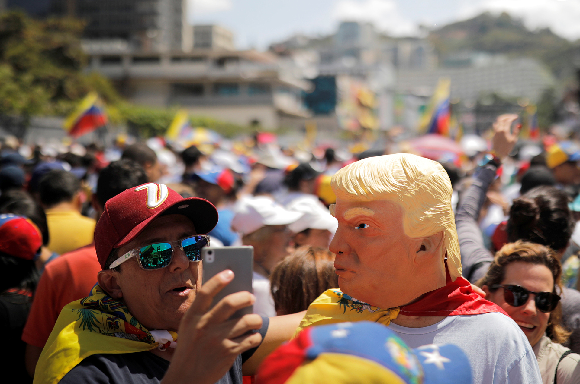 Un hombre lleva una máscara del presidente estadounidense, Donald Trump y posa en las fotos, durante la marcha opositora en Venezuela (REUTERS/Carlos Barria)