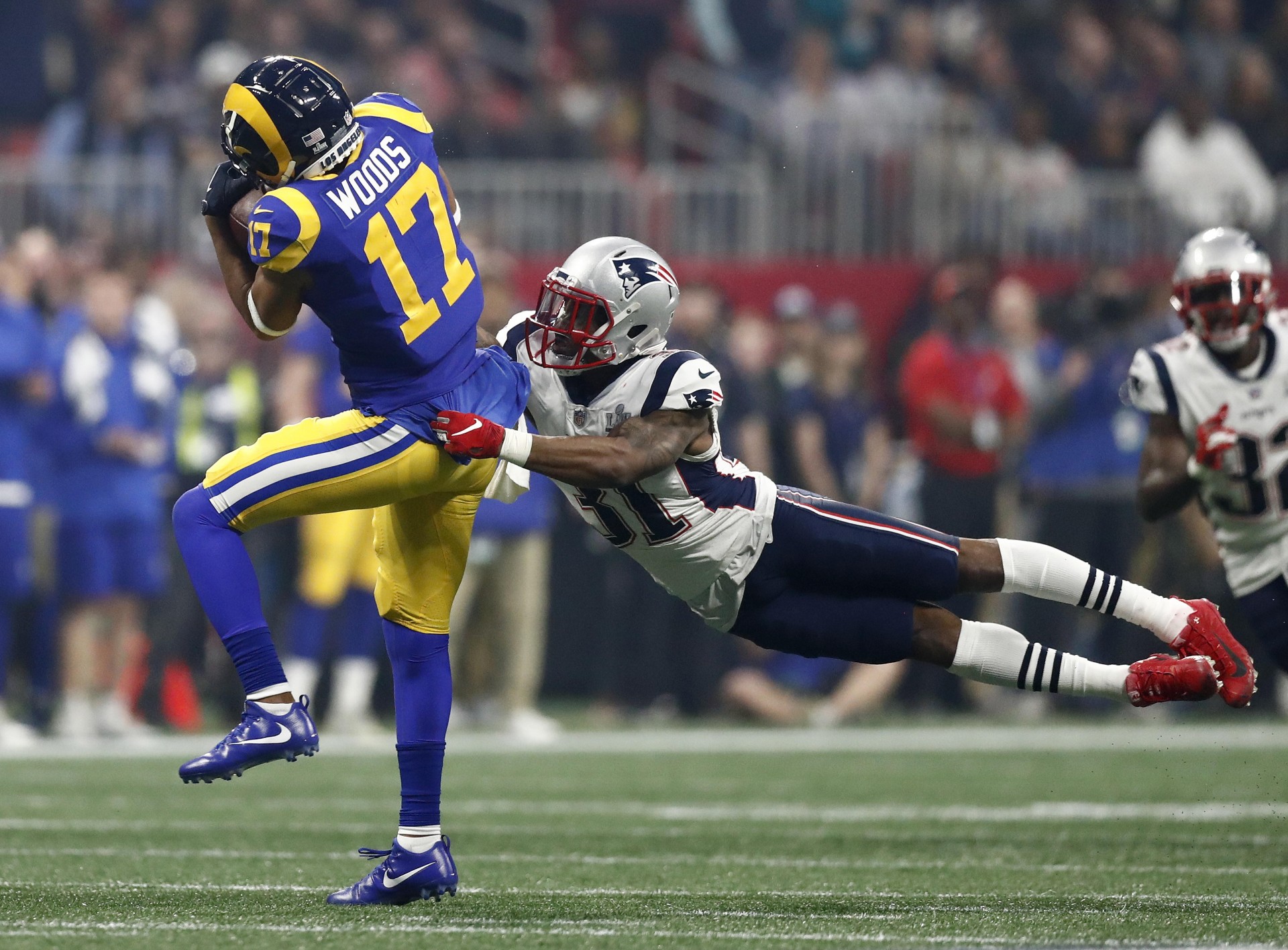 El receptor Robert Woods de Los Angeles Rams se lanza en una atrapada mientras el defensa de los New England Patriots, Jonathan Jones , defiende durante la segunda mitad del Super Bowl.