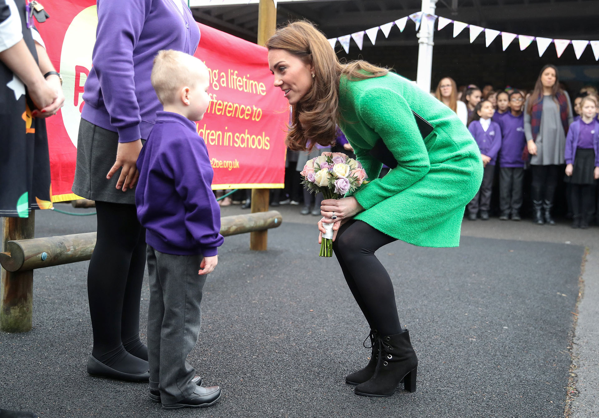 La duquesa de Cambridge hablando con uno de los niños de la escuela