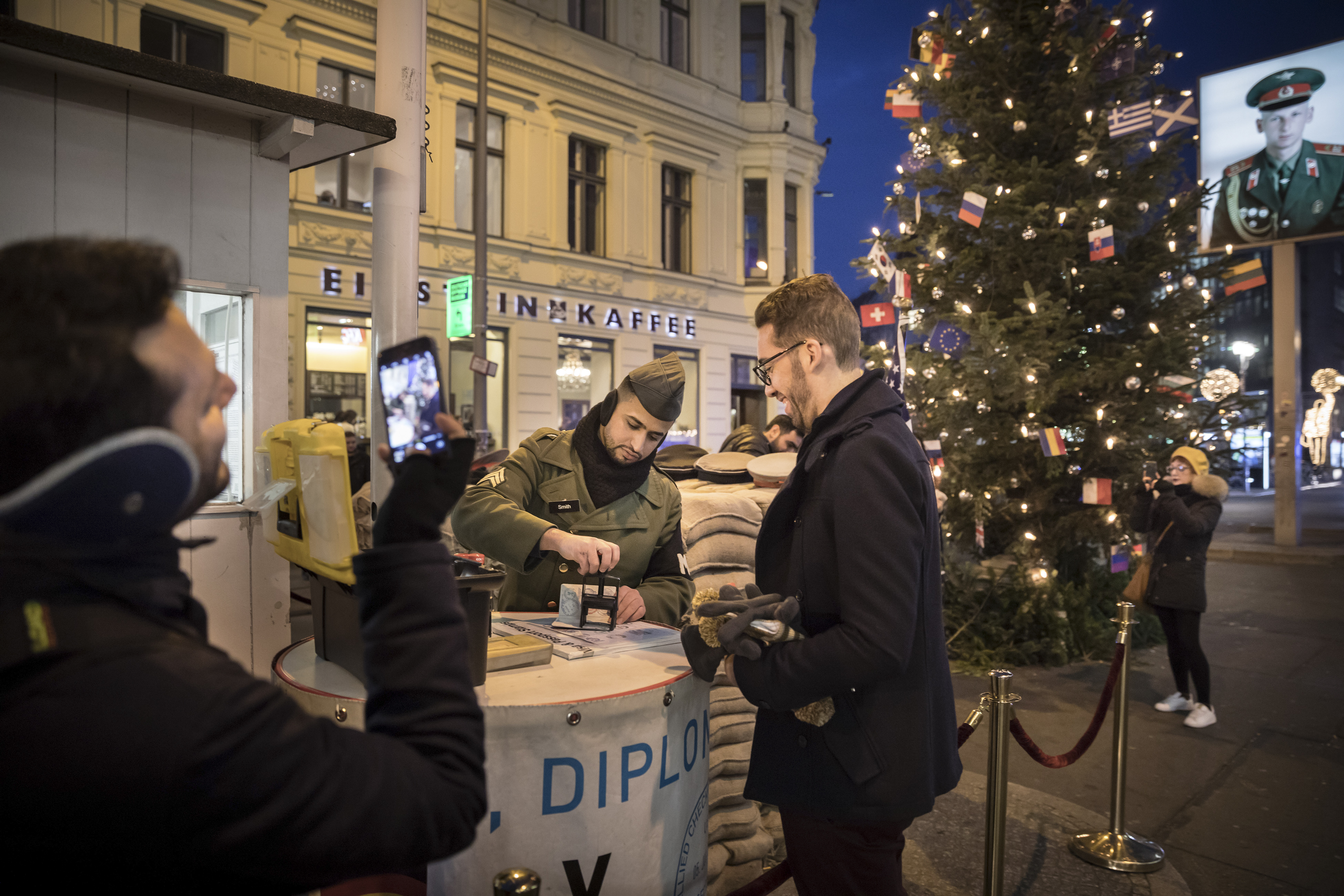 Personas disfrazadas de soldados posan para fotografías con los turistas por una cuota en el puesto de control, el cual ahora es administrado por el Museum Haus am Checkpoint Charlie. (Gordon Welters/The New York Times)