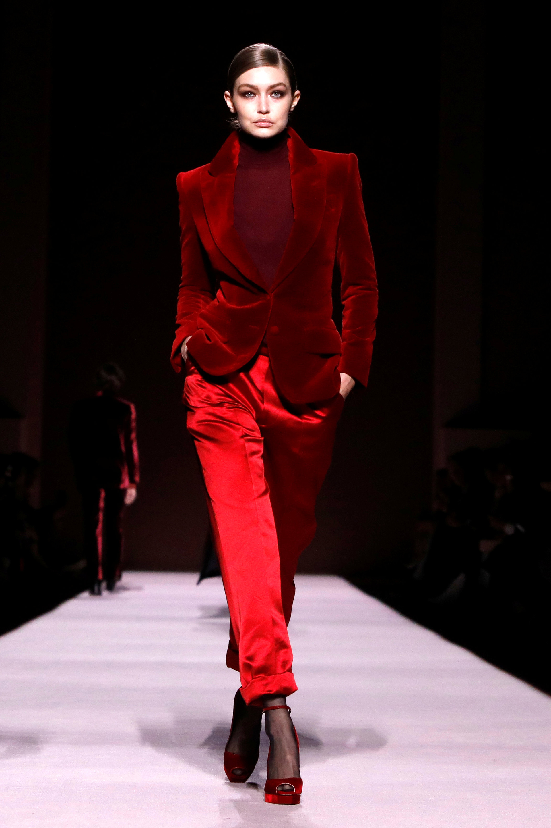 Gigi Hadid desfiló para Tom Ford luciendo un conjunto en total red. Pantalón de raso al tobillo, saco con hombreras de chiffón y polera. El detalle chic particular de la colección, las sandalias con pulsera y punta “boca de pez”