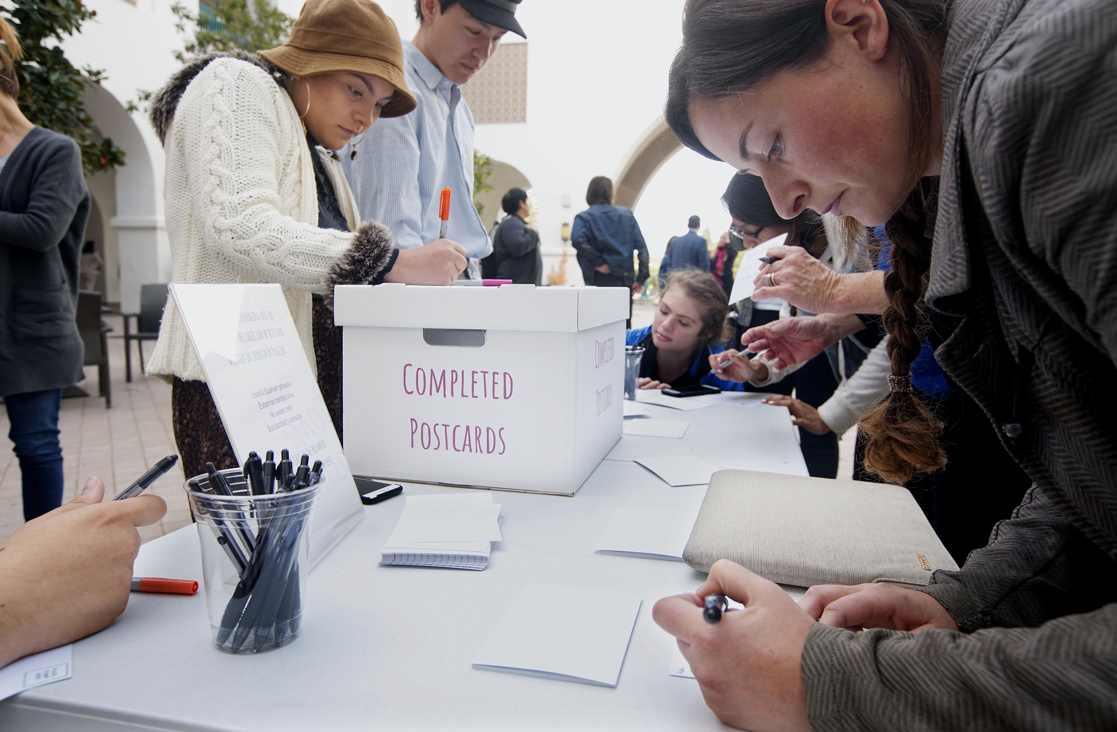 Un grupo de personas en la Universidad de San Diego escribe cartas a los migrantes. (Sandy Huffaker/The New York Times)