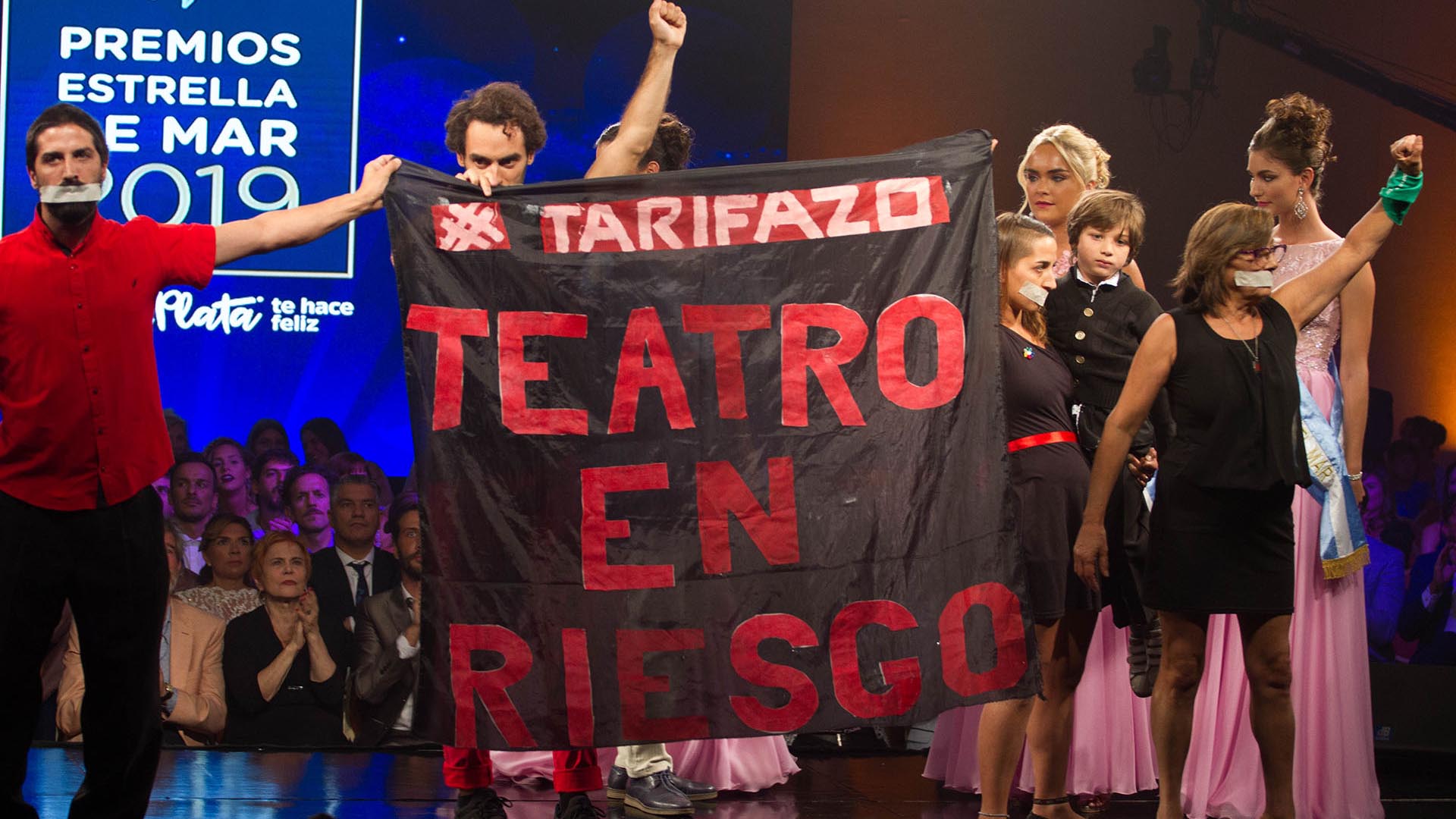 Durante la entrega de los Premios Estrella de Mar, los integrantes de “El séptimo fuego” subieron al escenario con cintas adhesivas en su boca y mostraron una bandera en contra de los aumentos de tarifas que no pudo verse durante la transmisión de la TV Pública (Cintia Haag)