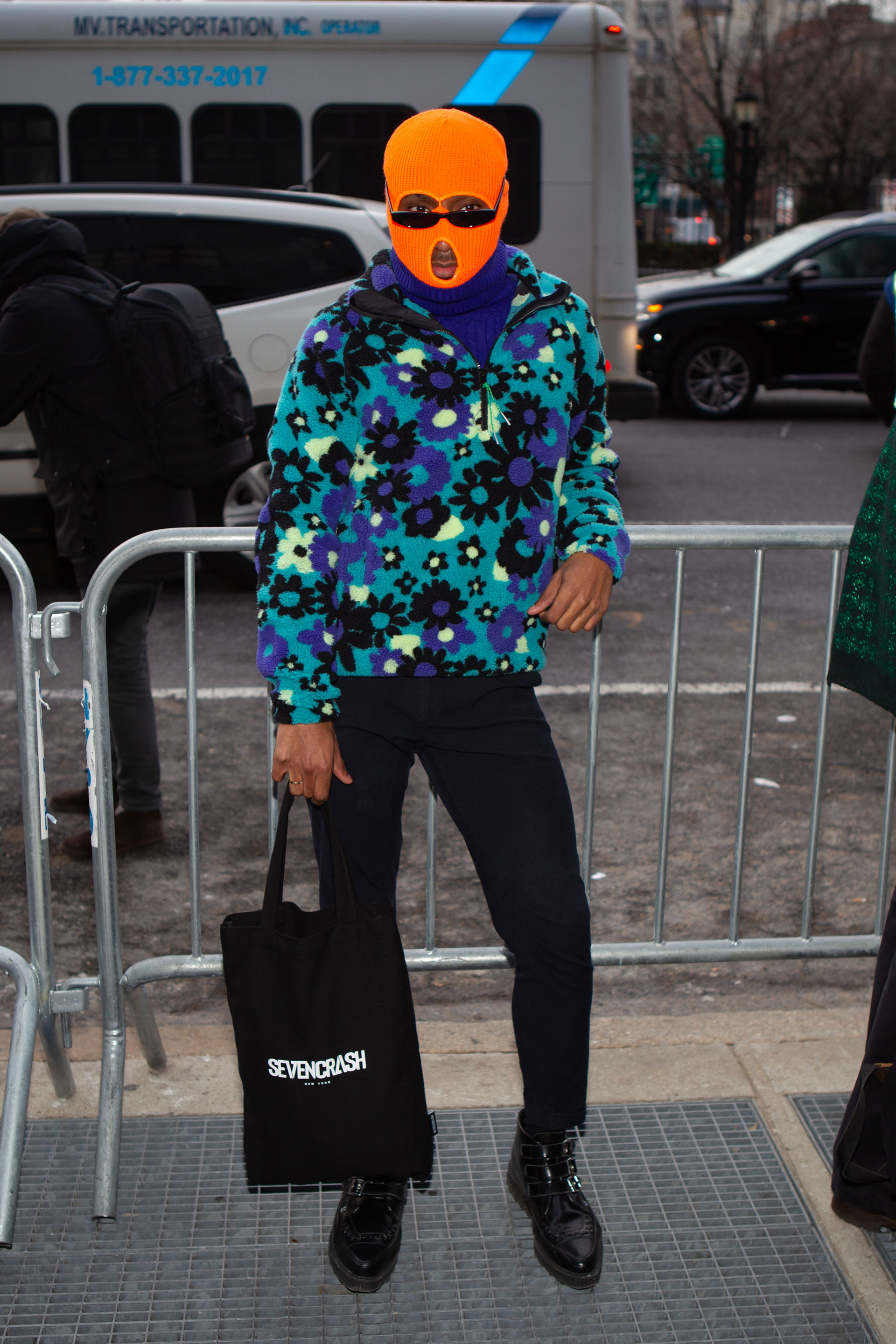 Polar estampado de flores y un pasamontaña en naranja flúor. Con sweater de cuello polera debajo y pantalón de vestir con borceguíes acharolados en punta
