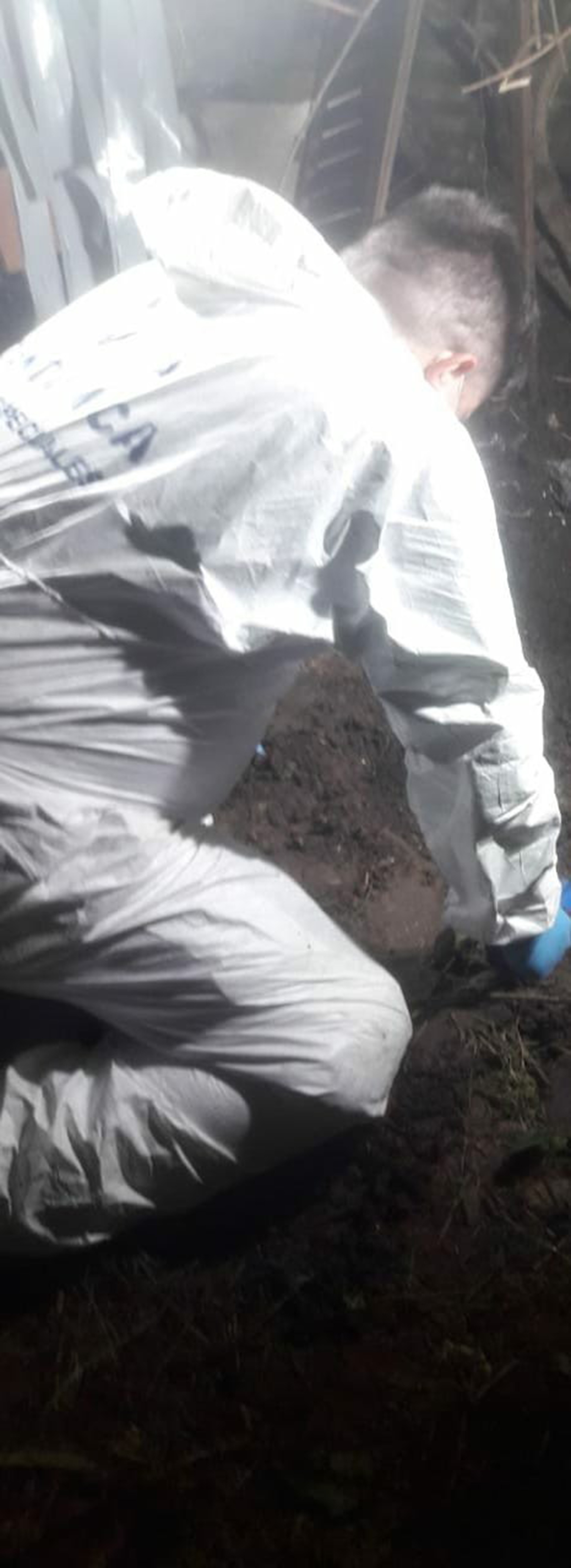 Personal de policía científica, durante la extracción del cuerpo