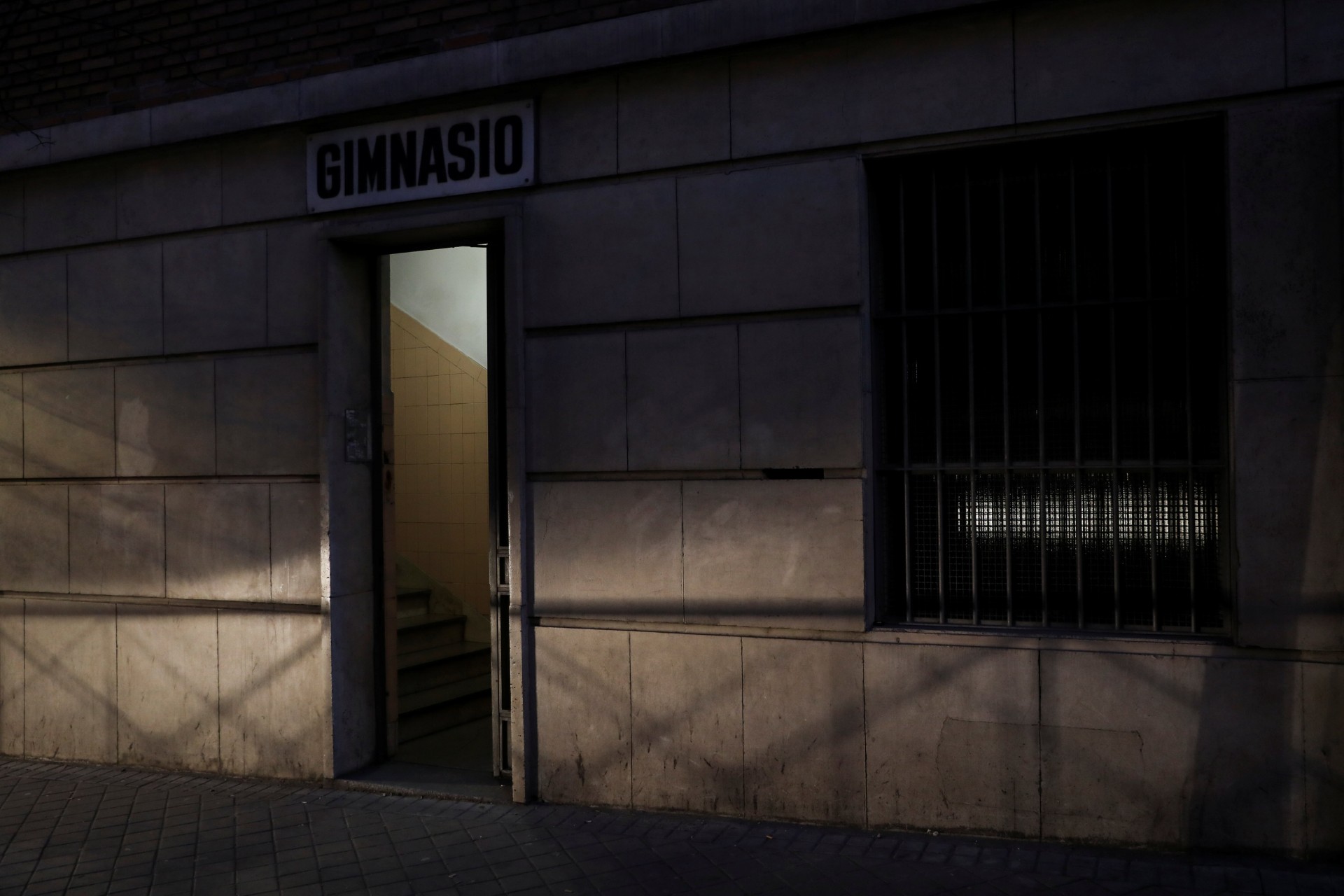 Los faros de un automóvil que pasa en Madrid, España, el 14 de febrero de 2019, iluminan la entrada al gimnasio del colegio donde Fernando García-Salmones, de 58 años, dice que fue violado por un sacerdote hace casi 44 años. En una tarde lluviosa en 1975, García-Salmones estaba solo en el patio de recreo de su escuela cuando lo llamaron a la habitación de su abusador para que se secara. “Se dio cuenta de que era vulnerable e indefenso, un pequeño ratón solitario”, dijo. Cuando García-Salmones decidió llevar el caso a los tribunales en 1995, ya había ejecutado su estatuto de limitaciones.