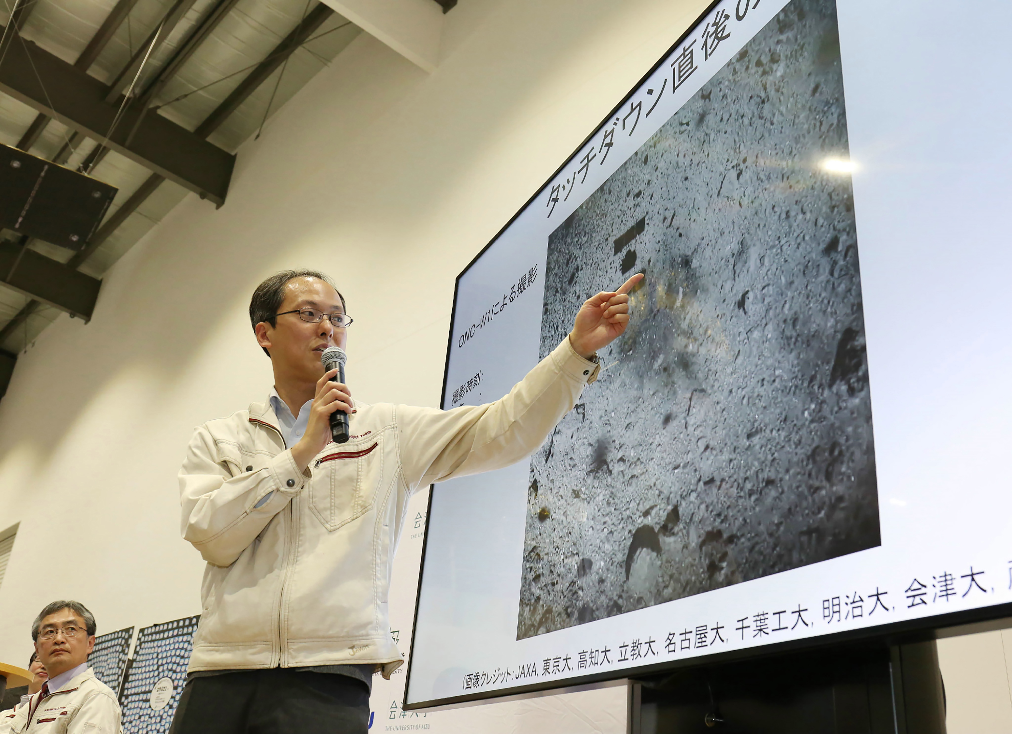 Yuichi Tsuda, uno de los responsables de la misión, muestra una foto de la superficie de Ryugu tomada antes por la sonda Hayabusa2 (JIJI PRESS/AFP)