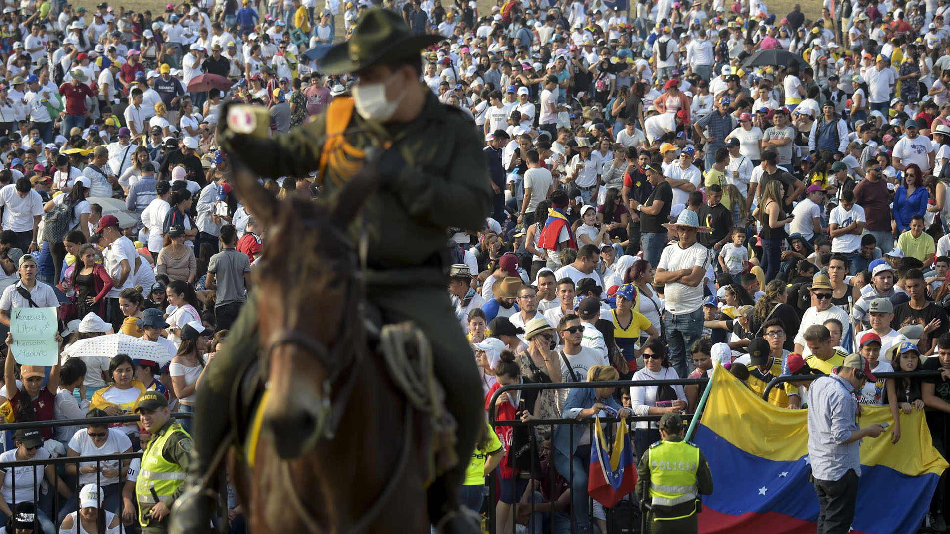 Un policía a caballo en guardia mientras la gente espera el comienzo del concierto “Venezuela Aid Live”, organizado por el multimillonario británico Richard Branson para recaudar fondos para la ayuda humanitaria a Venezuela en el Puente Internacional Tienditas en Cúcuta, Colombia, el 22 de febrero de 2019. (AFP)