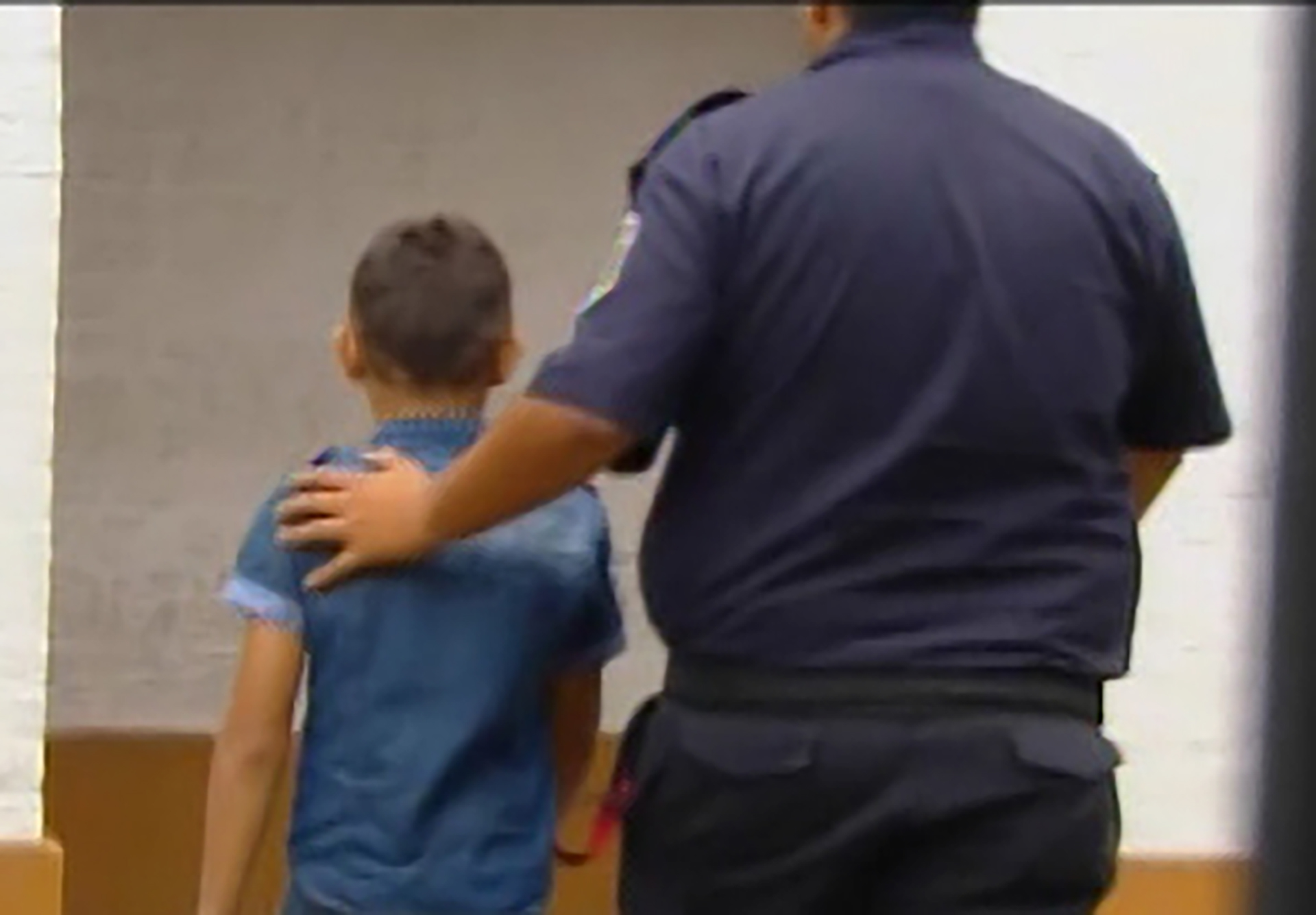 Un policía acompaña al menor, en el ingreso a la fiscalía de Moreno