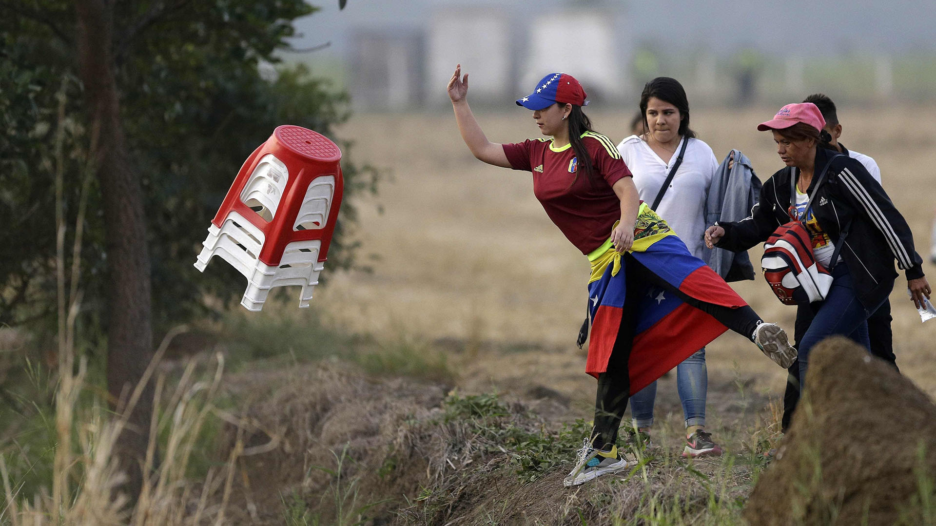 Una mujer venezolana agarra un juego de taburetes de plástico cuando llega para el concierto de Venezuela Aid Live en el lado colombiano del Puente Internacional Tienditas en las afueras de Cúcuta, Colombia, el viernes 22 de febrero de 2019, en la frontera con Venezuela. (AP)