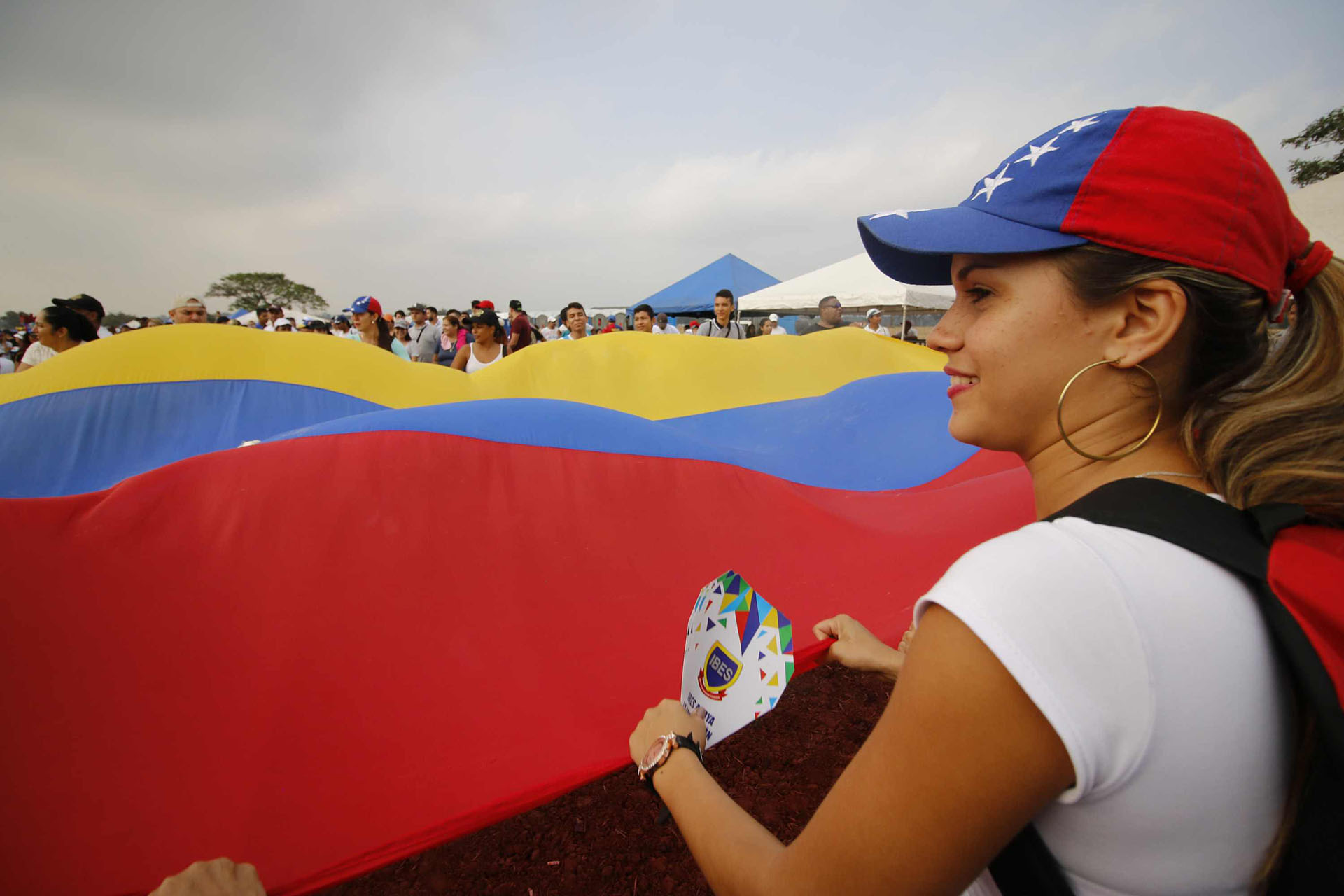 Una gran bandera de Venezuela se desplegó entre la multitud en el concierto “Venezuela Aid Live”. (AFP)