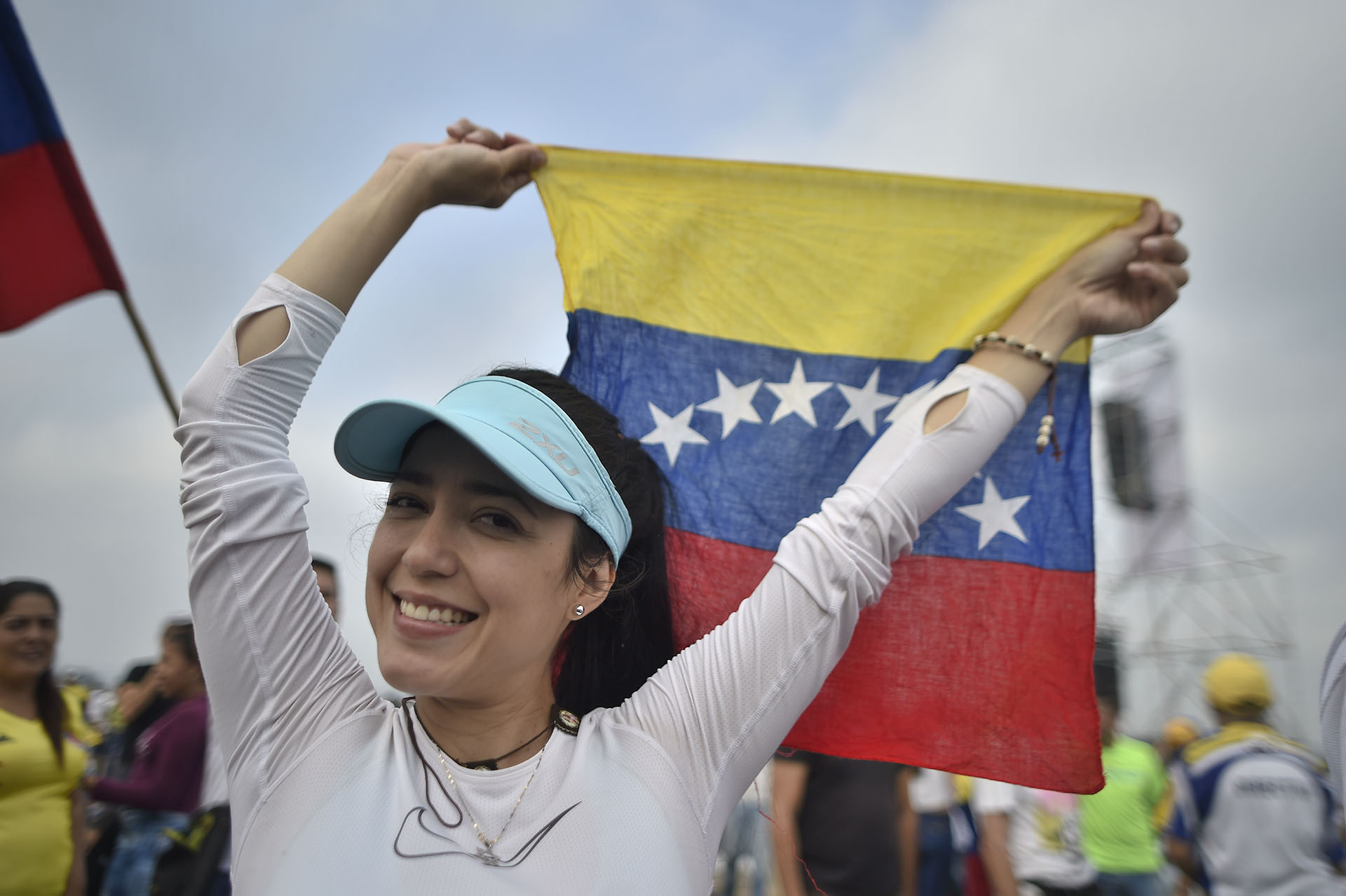 Una mujer alza una bandera de Venezuela. (AFP)