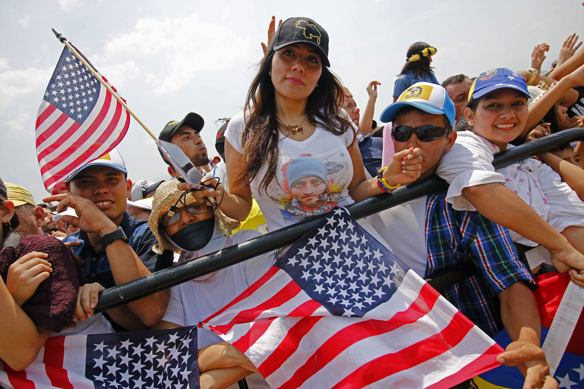 Una mujer sostiene una bandera estadounidense mientras participa en el concierto “Venezuela Aid Live”. (AFP)