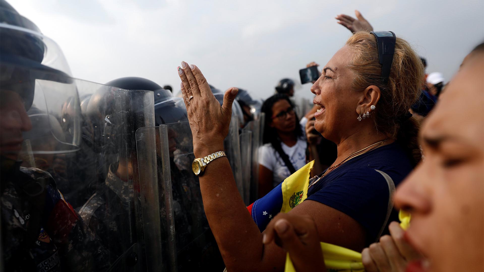 Los partidarios de la oposición venezolana exigen cruzar la línea fronteriza entre Colombia y Venezuela en el puente Simón Bolívar cuando las fuerzas de seguridad de Venezuela se paran en la línea fronteriza bloqueando su camino en las afueras de Cúcuta, Colombia (Reuters)