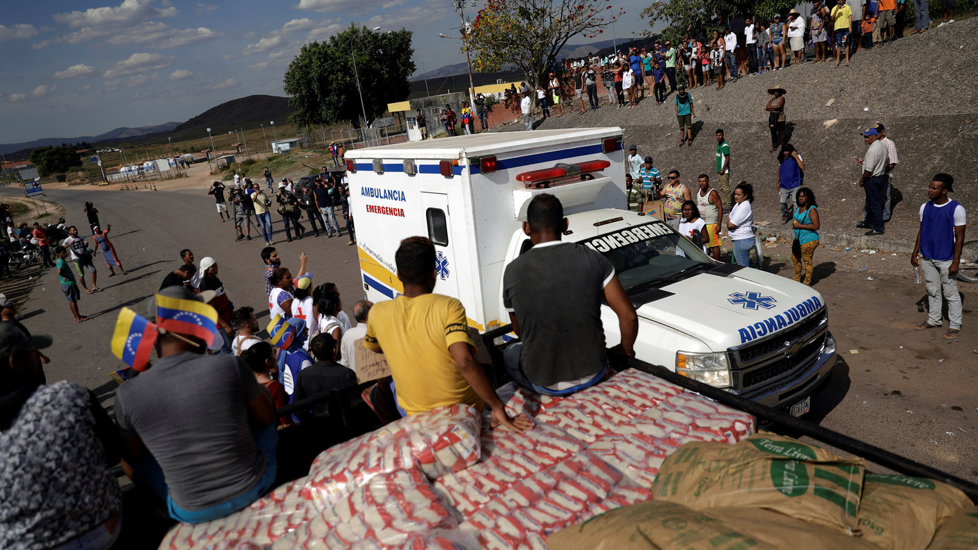 Una ambulancia que transporta personas heridas de Venezuela, pasa junto a un camión con ayuda humanitaria en la frontera entre Venezuela y Brasil en Pacaraima, Brasil (Reuters)