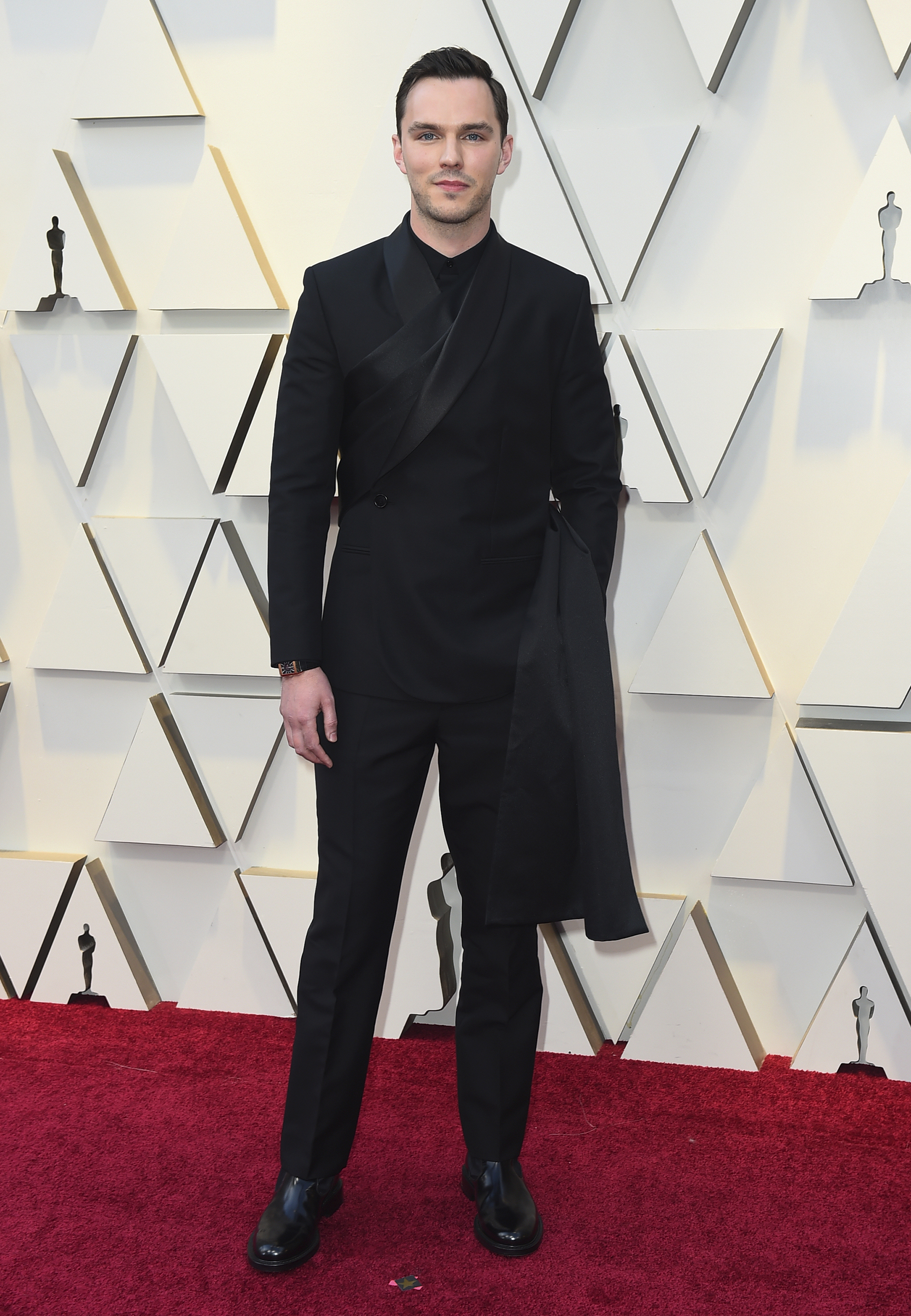 Nicholas Hoult con un look total black de Dior con un sash negro que cae al costado