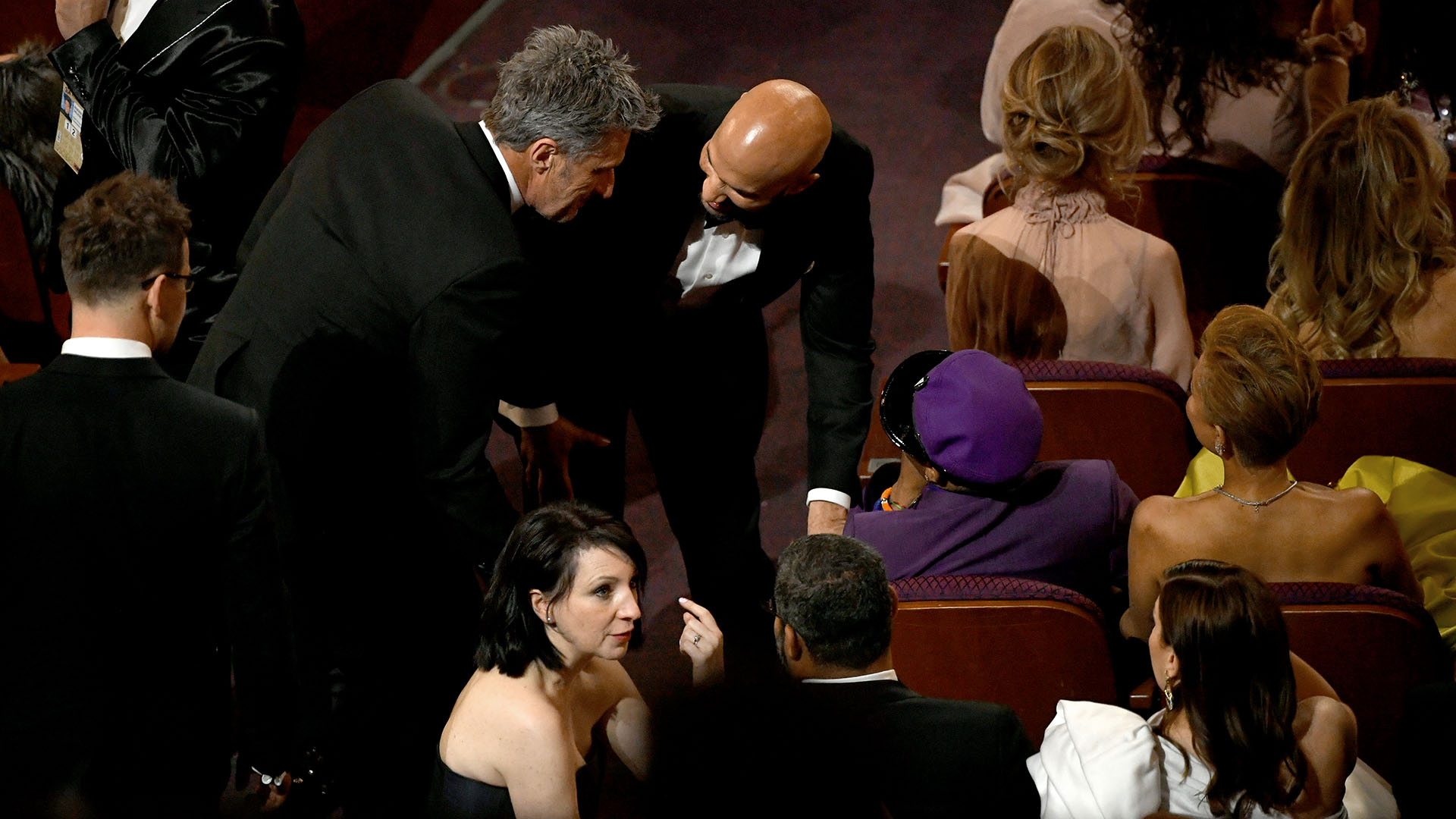 Spike Lee habla con sus productores mientras el elenco de “Green Book” recibe el Oscar
