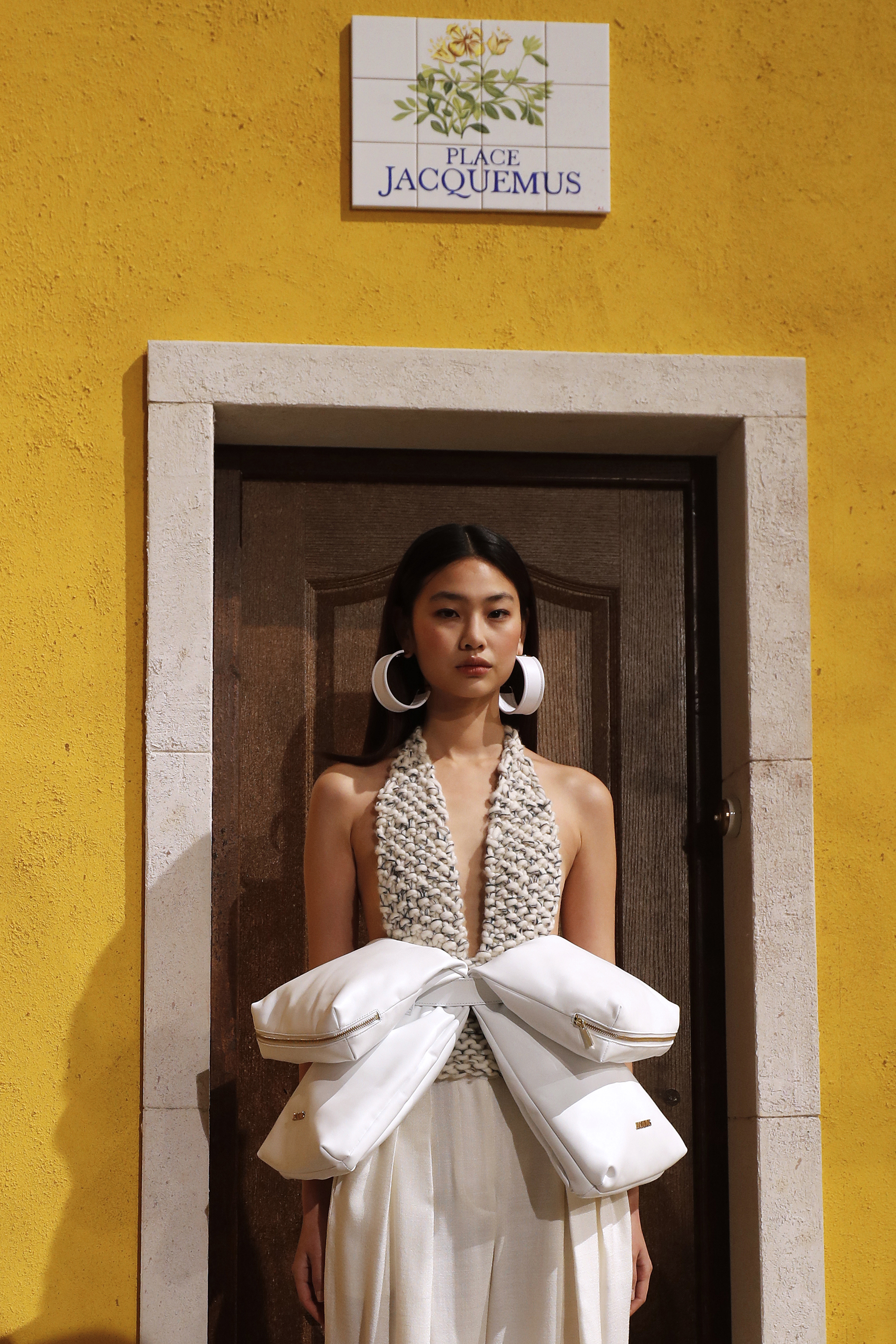 Un extravagante diseño de Jacquemus. Una maxi riñonera con 4 compartimientos. Un body tejido y un pantalón tiro medio de lino