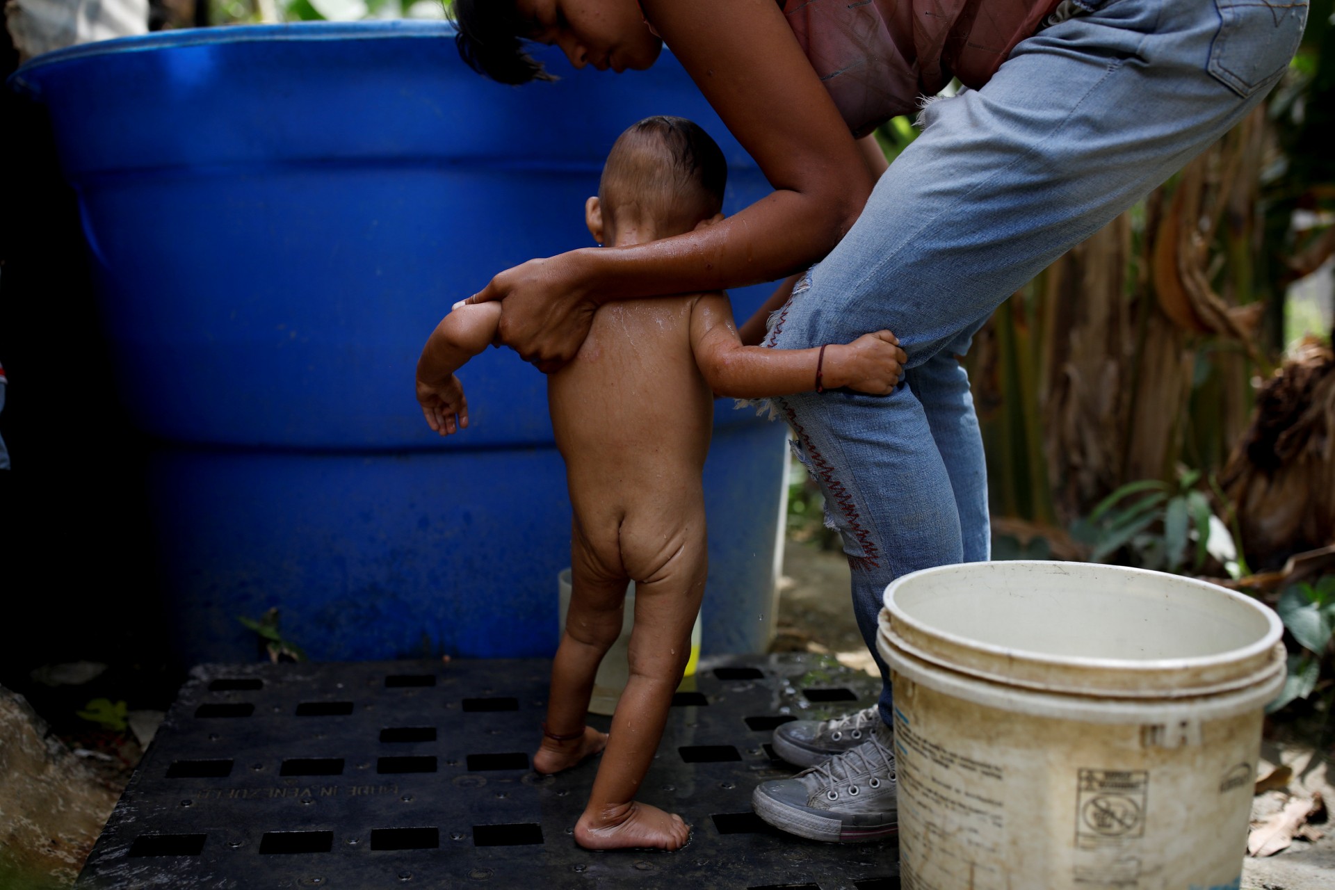 María Guitia baña a su hija Yeibe Medina en su casa cerca de San Francisco de Yare, Venezuela, el 18 de febrero de 2019.