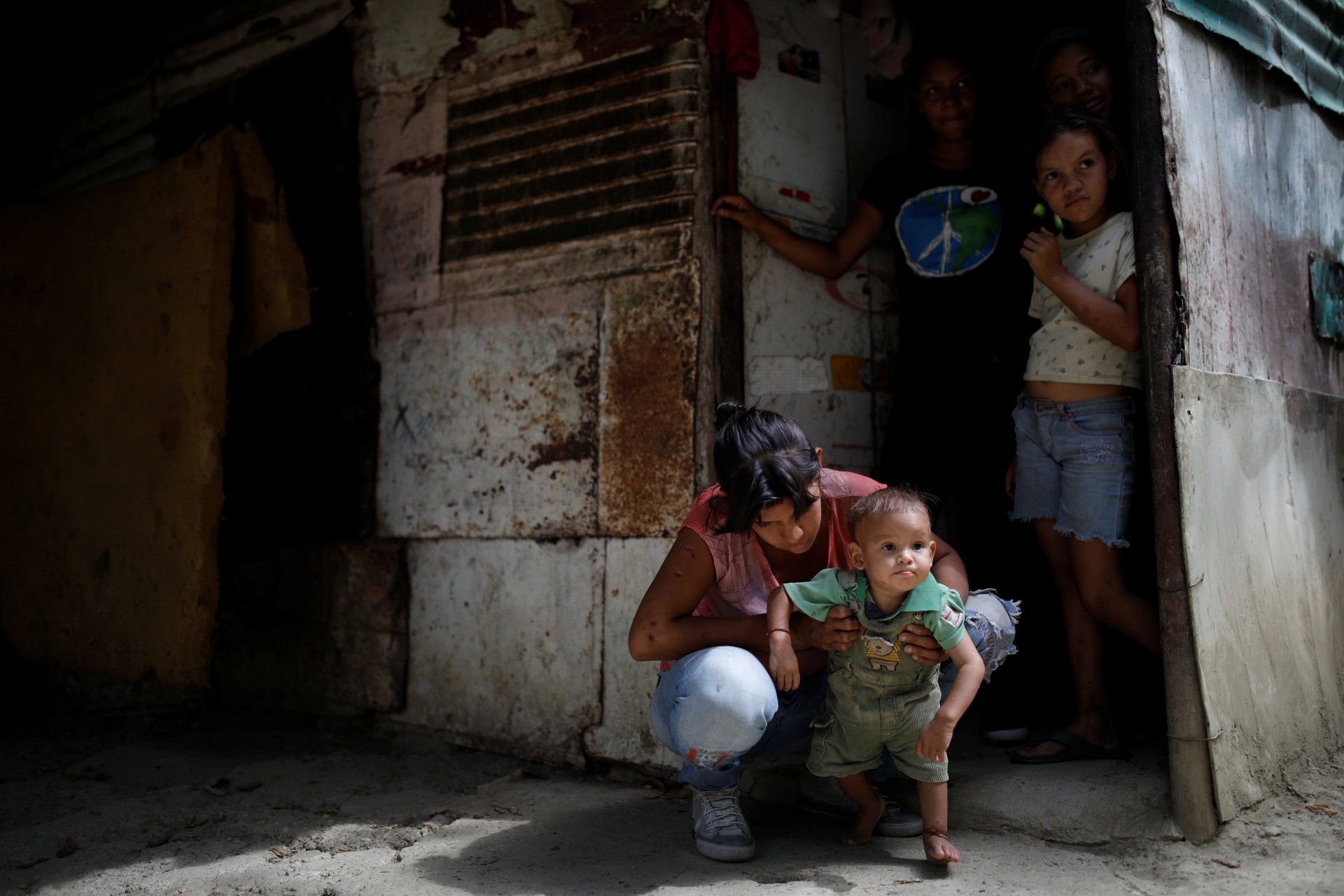 María Guitia sostiene a su hijo de un año, Yeibe Medina, fuera de su hogar cerca de San Francisco de Yare, Venezuela, el 18 de febrero de 2019.