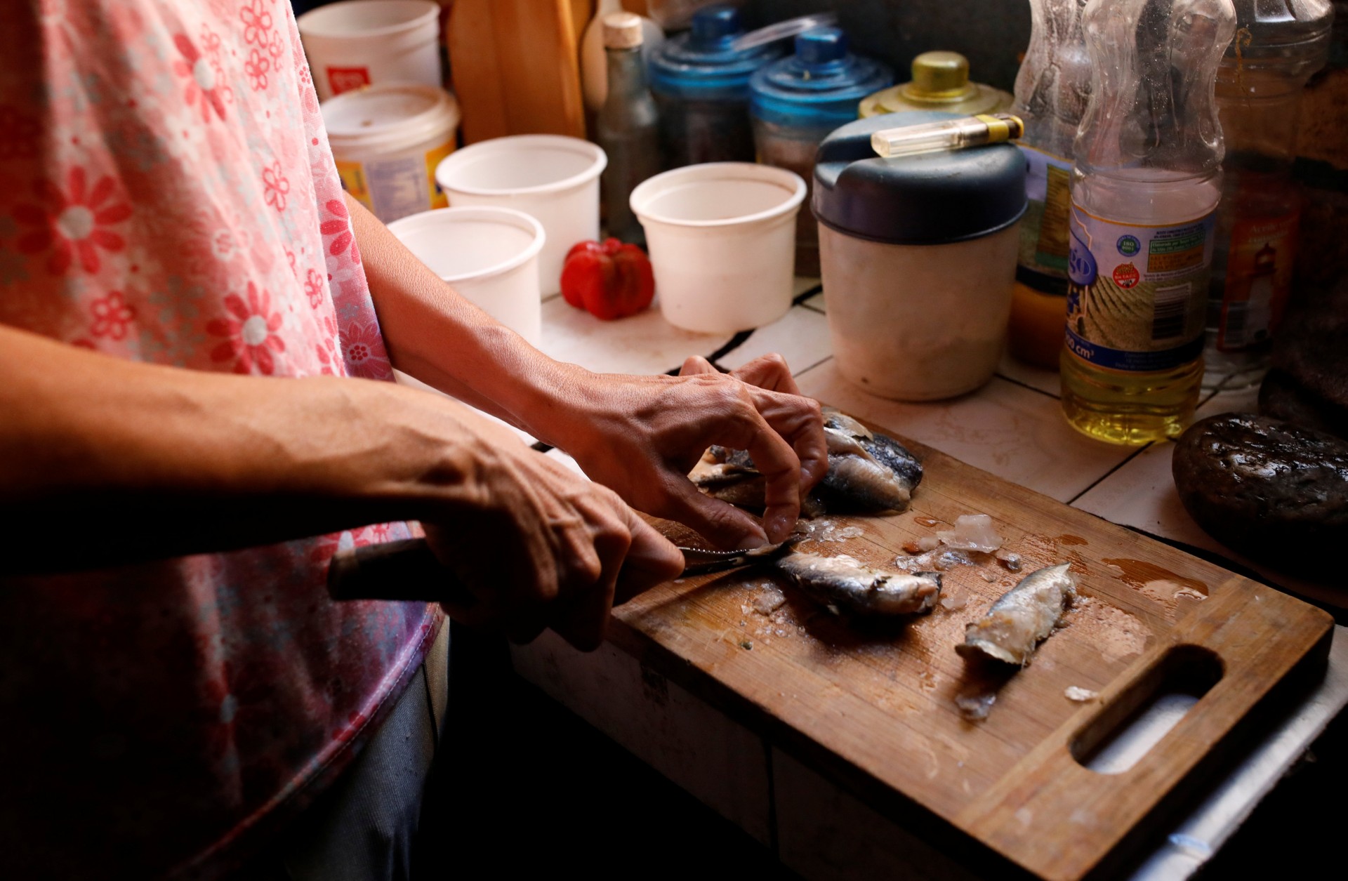 Yaneidi Guzmán prepara unas sardinas en su cocina. Guzmán ha perdido un tercio de su peso en los últimos tres años debido a que el colapso económico de Venezuela hizo que la comida fuera inaccesible y ahora espera que la oposición tenga éxito. En urgente necesidad de ayuda exterior.