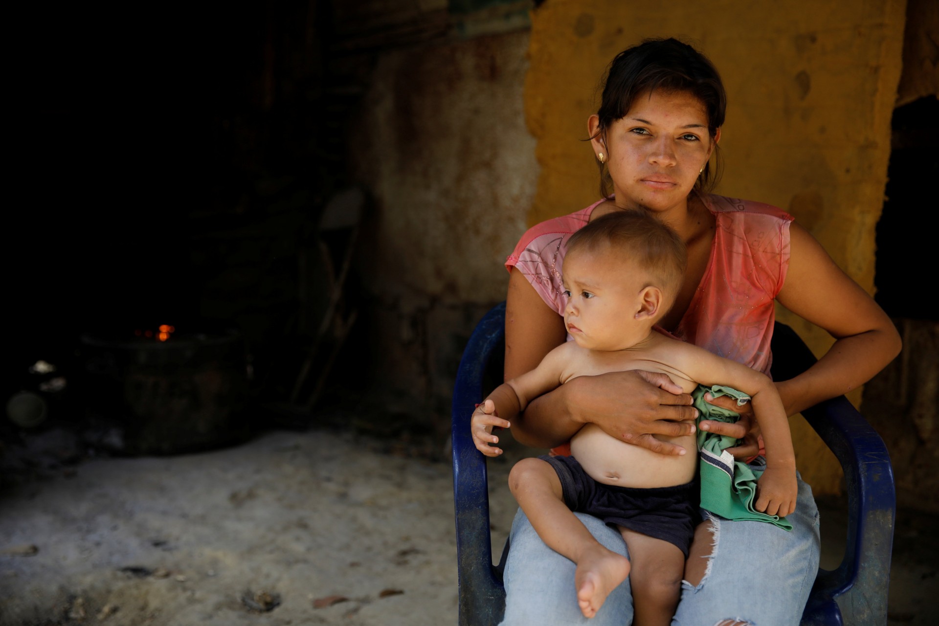 María Guitia posa una fotografía con su bebé de un año Yeibe Medina sobre su rodilla en su casa cerca de San Francisco de Yare, Venezuela, 18 de febrero de 2019. La pareja vive con los cinco hermanos y padres de Guitia en un cobertizo de una habitación.