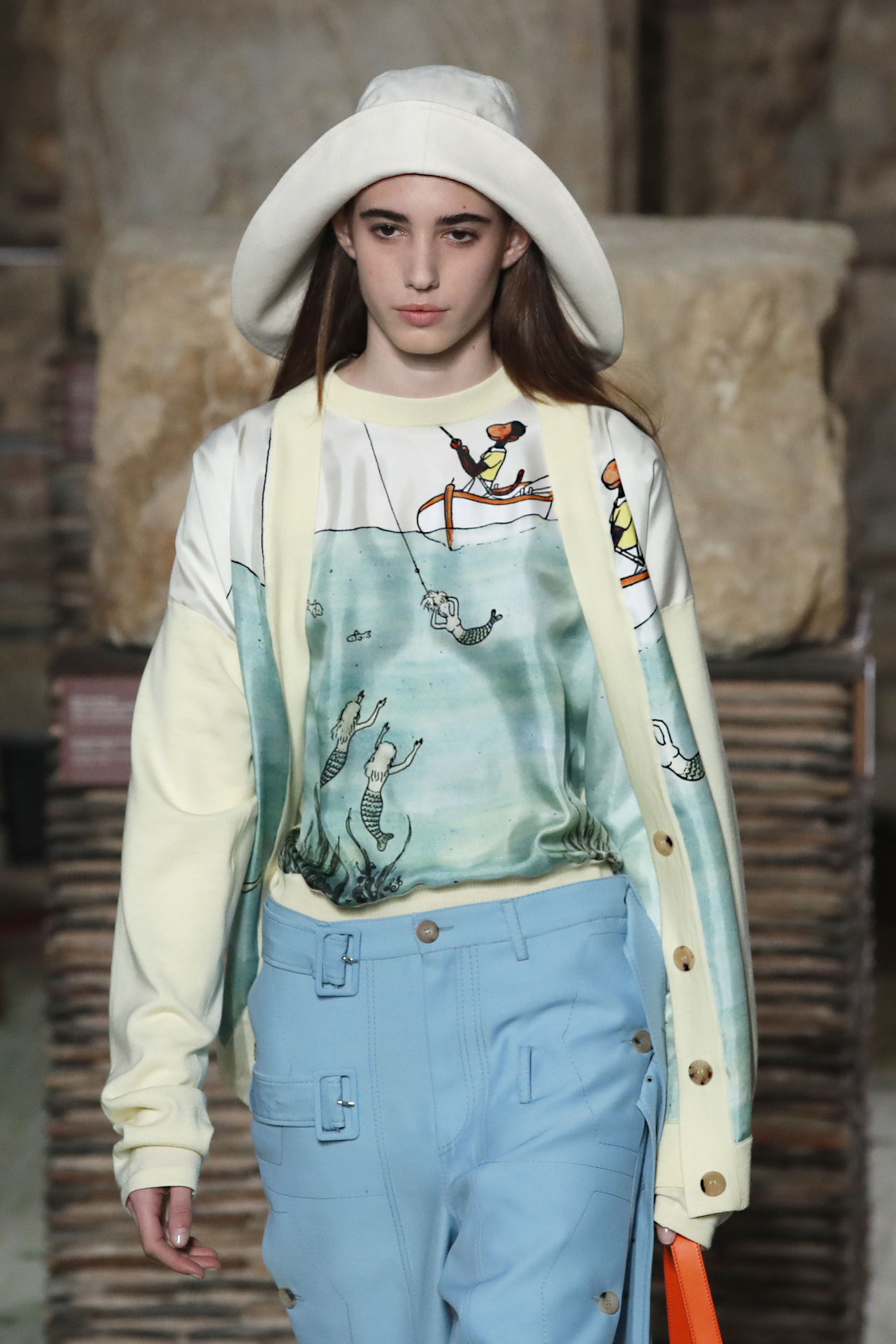Colores pasteles y off white. Combinación de estampados con full color, buzos oversized, pantalones con doble herraje. Como accesorio, gorro impermeable de ala ancha