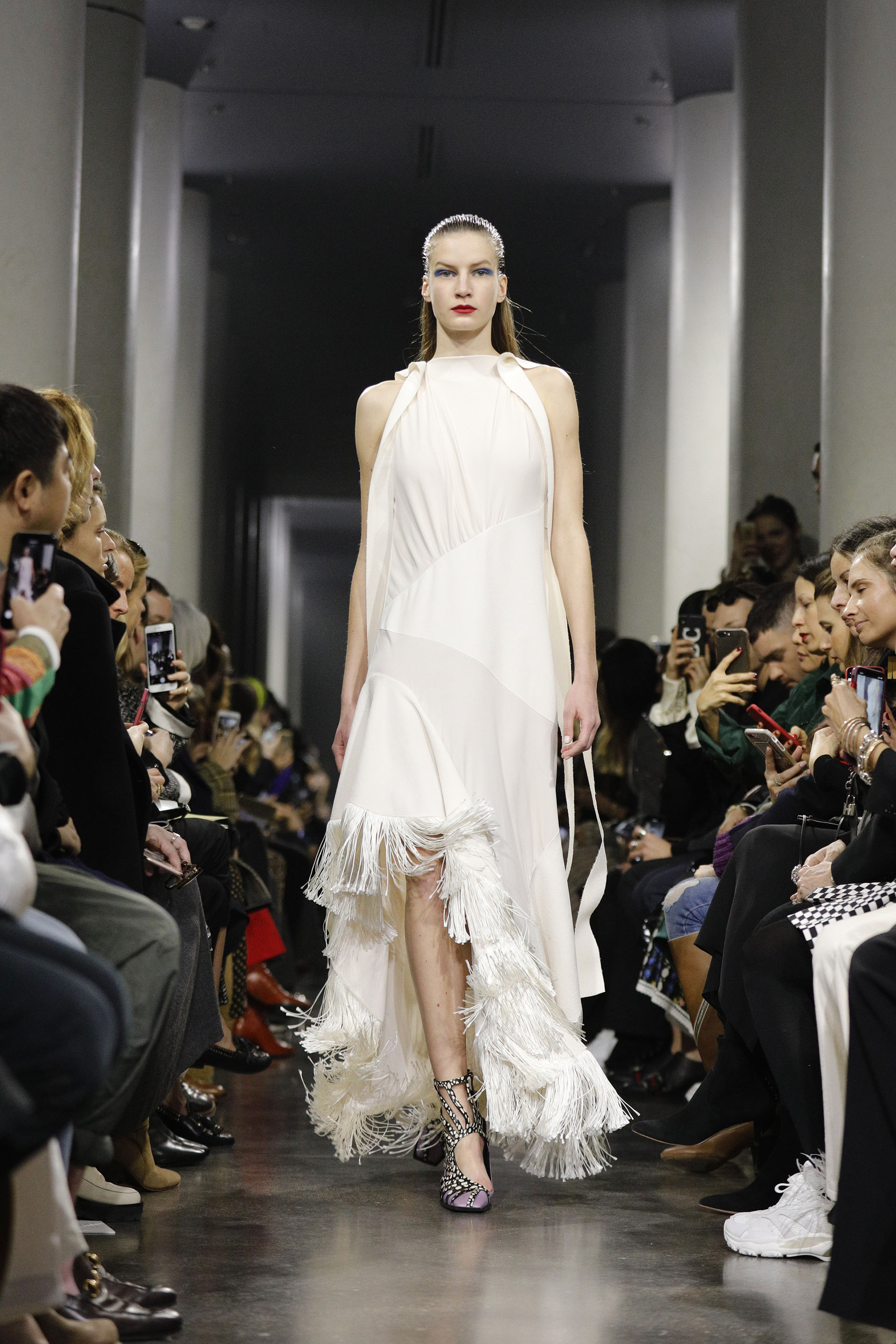 Off white, cuello halter, sin mangas, con flecos y tajo irregular. Con sandalias de animal print de cebra y lilas hasta el tobillo