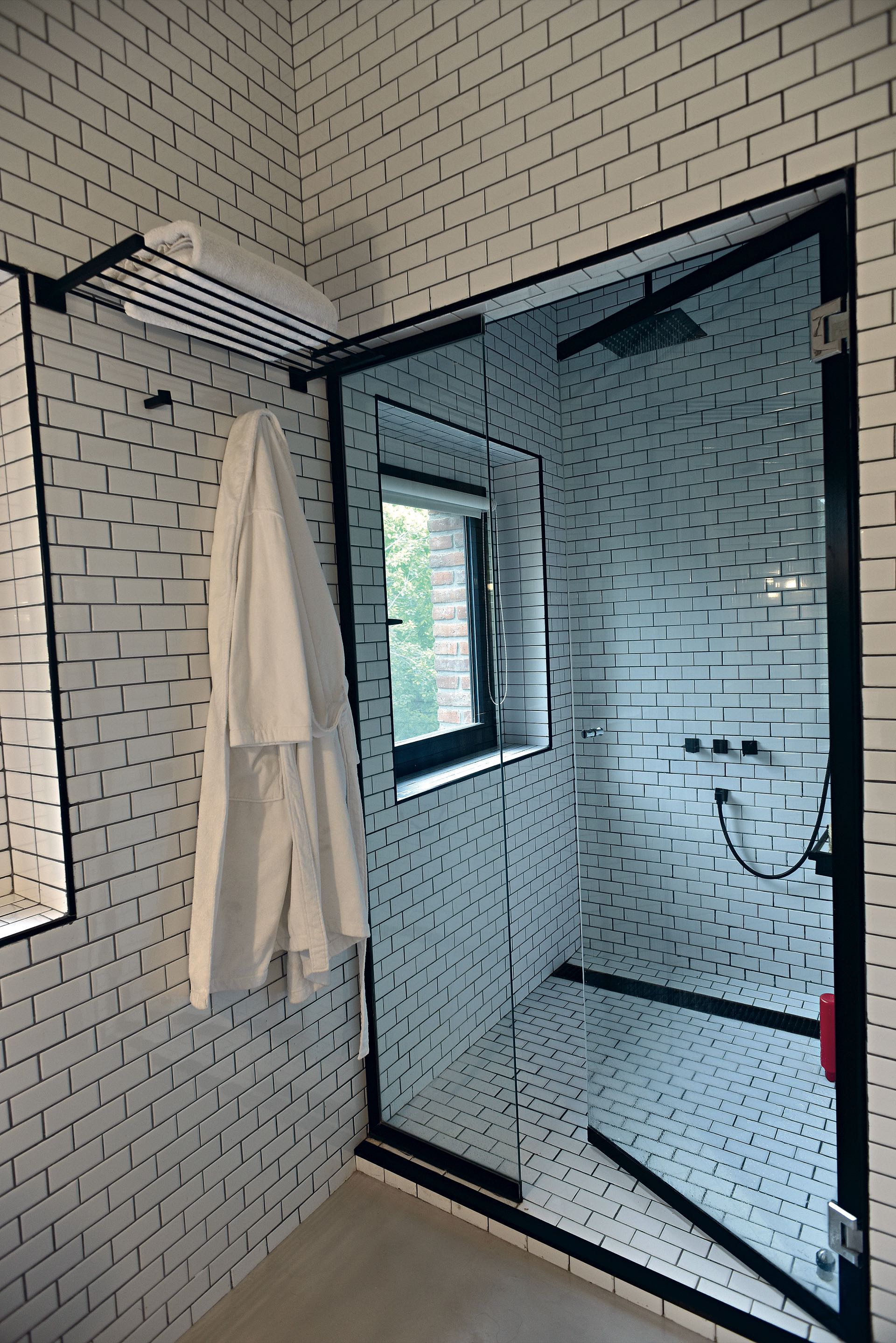 La ducha del baño principal se destaca por una mampara con marco y perfiles negros.