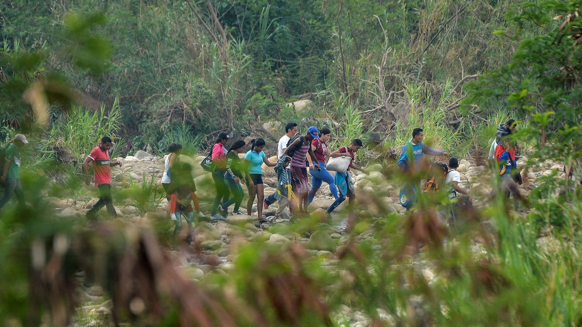 La gente cruza a través de “Trochas” – senderos ilegales- a través del río Táchira desde San Antonio en Venezuela a Cúcuta en Colombia el 27 de febrero de 2019. (AFP)
