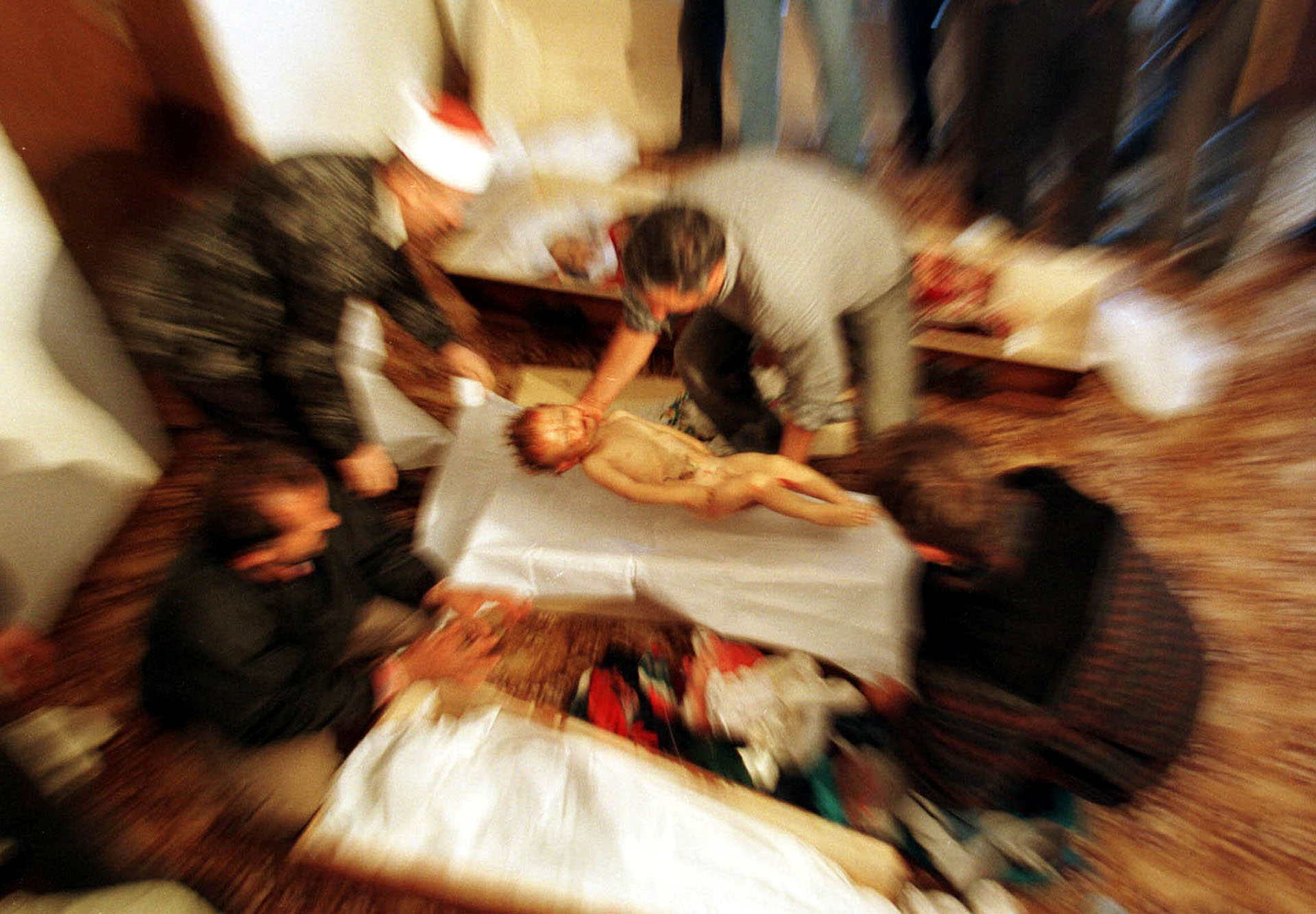 Un hombre albano coloca el cuerpo de Mozzlum Sylmetaj, de 2 años, en un ataúd cerca a los cuerpos de otros familiares asesinados por tropas yugoslavas en su cruce por Kosovo, en octubre de 1998