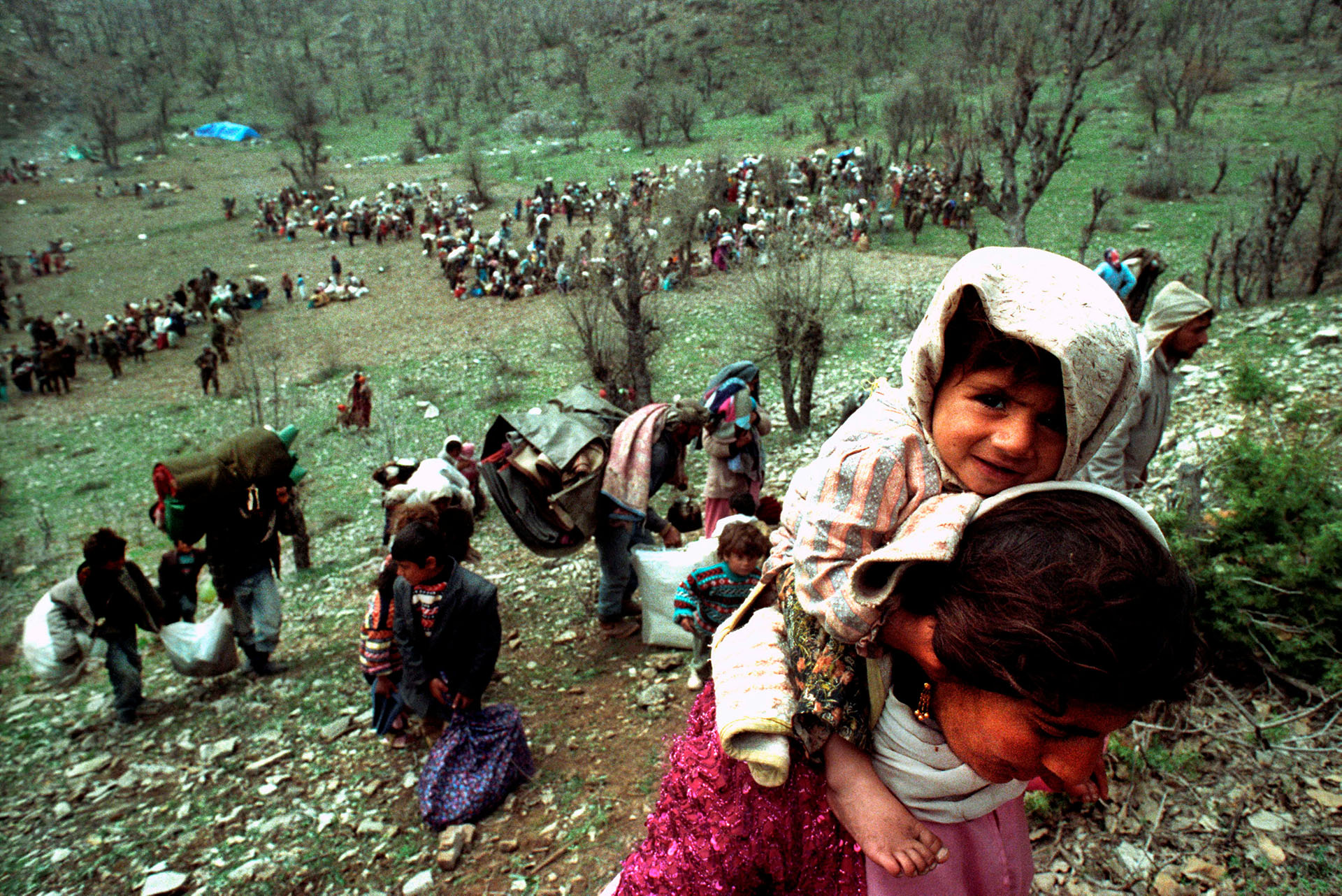La sonrisa de una niña mientras refugiados kurdos escapan en la frontera entre Irak y Turquía, en abril de 1992