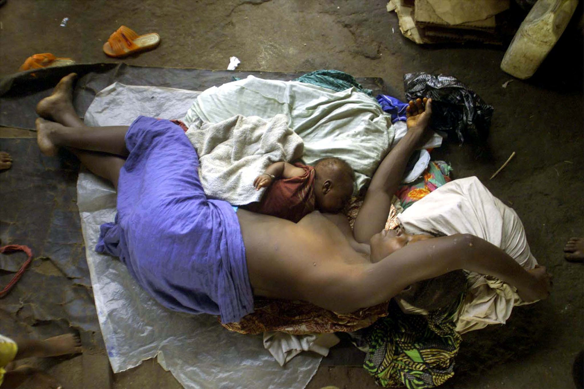 Fatmata Conteh, de Sierra Leona, yace junto a su bebé de seis semanas en un campo de refugiados cerca a Freetown, en mayo de 2000, tras huir de un ataque de fuerzas rebeldes