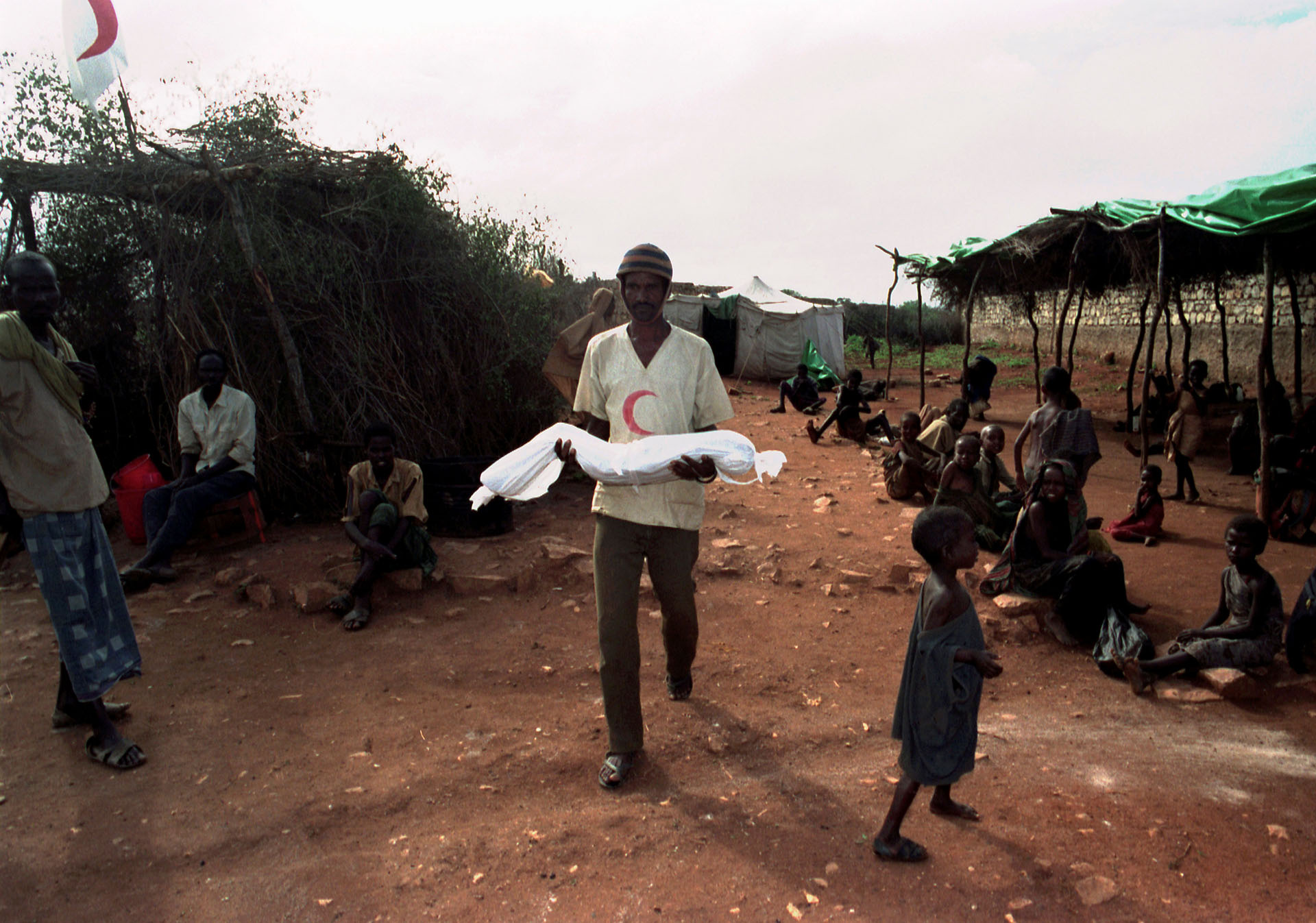 Un voluntario en Somalia carga el cuerpo de un menor en un campo de refugiados, en diciembre de 1992
