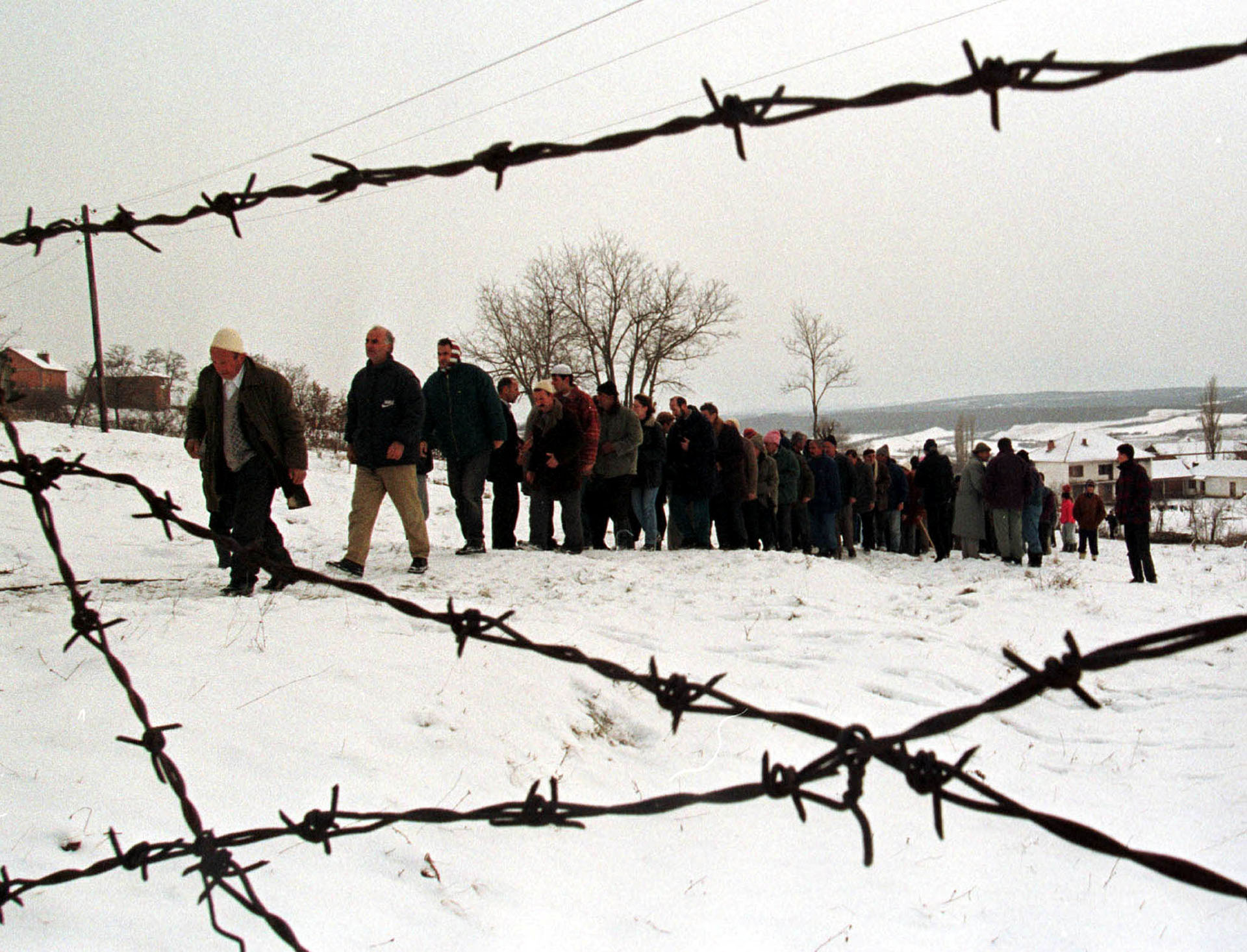 Una comunidad de Albania forma una fila para honrar a la familia de dos víctimas de la violencia étnica en Kosovo, en enero de 1999