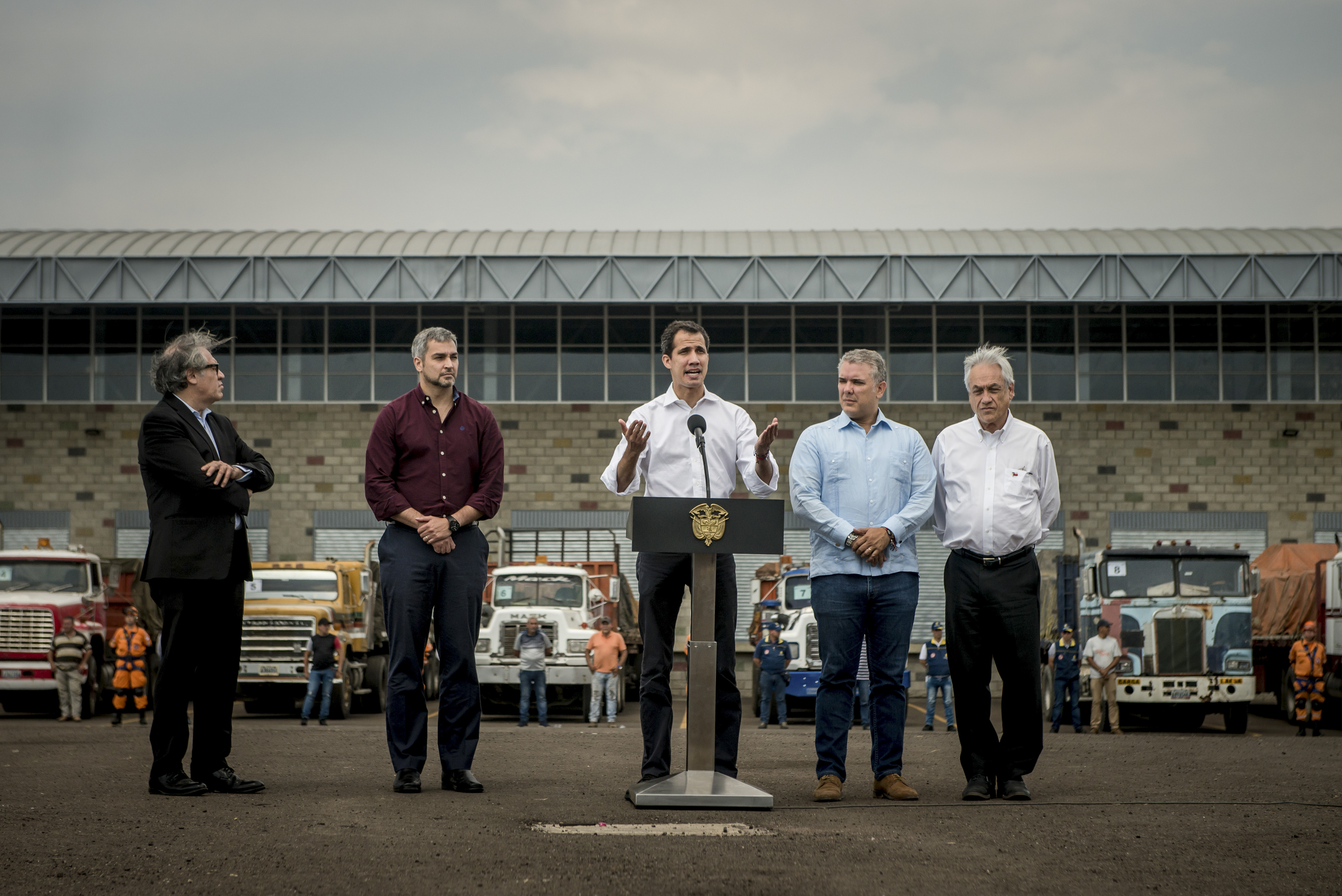 Guaidó, al centro, con los presidentes Sebastián Piñera de Chile, primero desde la derecha, e Iván Duque de Colombia, segundo desde la derecha, así como con Luis Almagro, secretario general de la Organización de Estados Americanos, OEA, primero desde la izquierda, frente a camiones con ayuda humanitaria en Colombia el 23 de febrero. (Meridith Kohut/The New York Times)