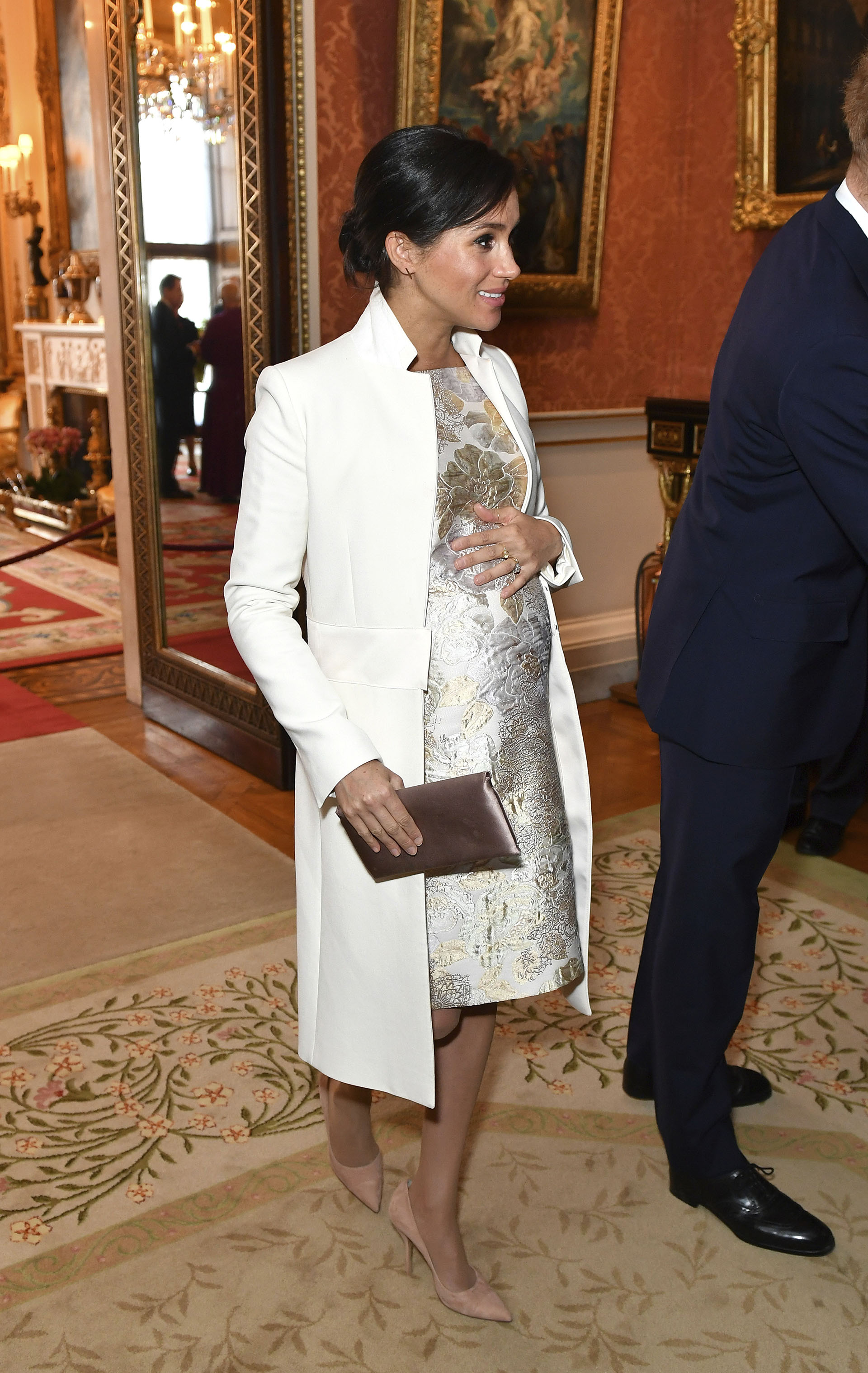 La duquesa de Sussex, asistió a una recepción en el Palacio de Buckingham, Londres, el martes 5 de marzo de 2019, para conmemorar el quincuagésimo aniversario de la investidura del Príncipe de Gales y lució un look deslumbrante vestido metálico y un abrigo blanco de Amanda Wakeley (AP)