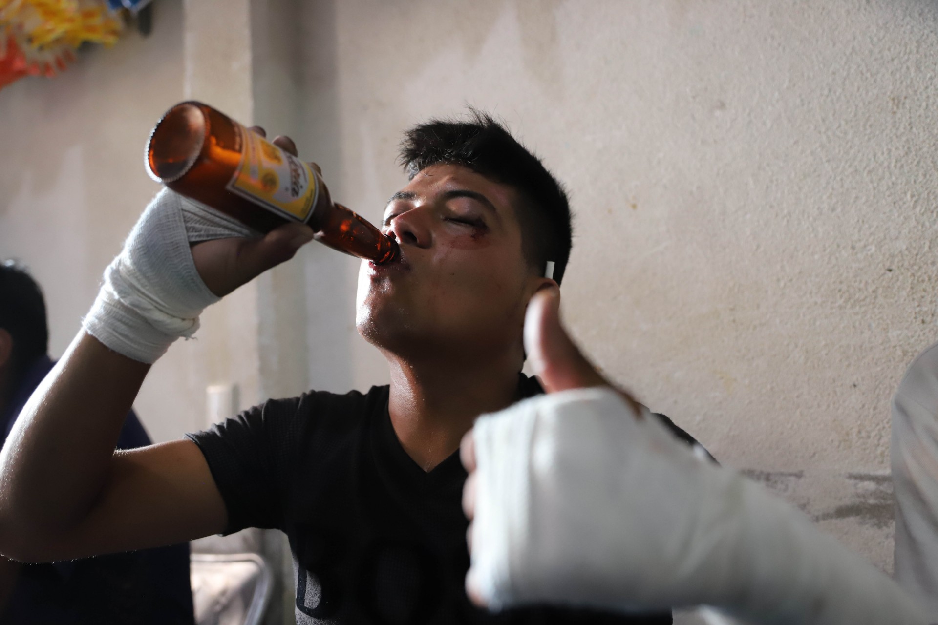 Un hombre bebe una cerveza después de participar en las peleas de los Xochimilcas en el estado de Guerrero.