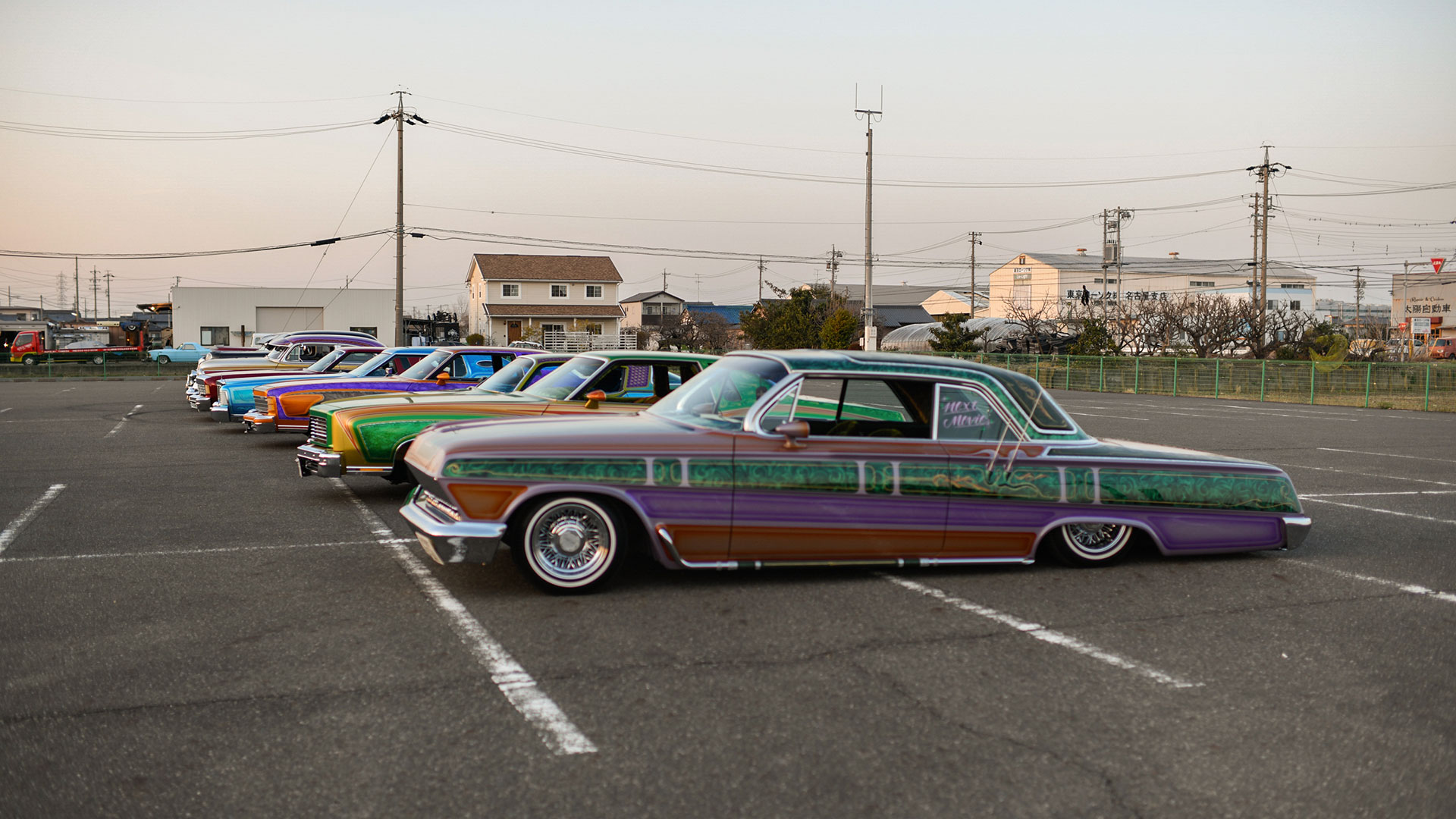 Un grupo de autos lowrider en un estacionamiento adyacente a la tienda de autos Cholos en Nagoya (The New York Times)