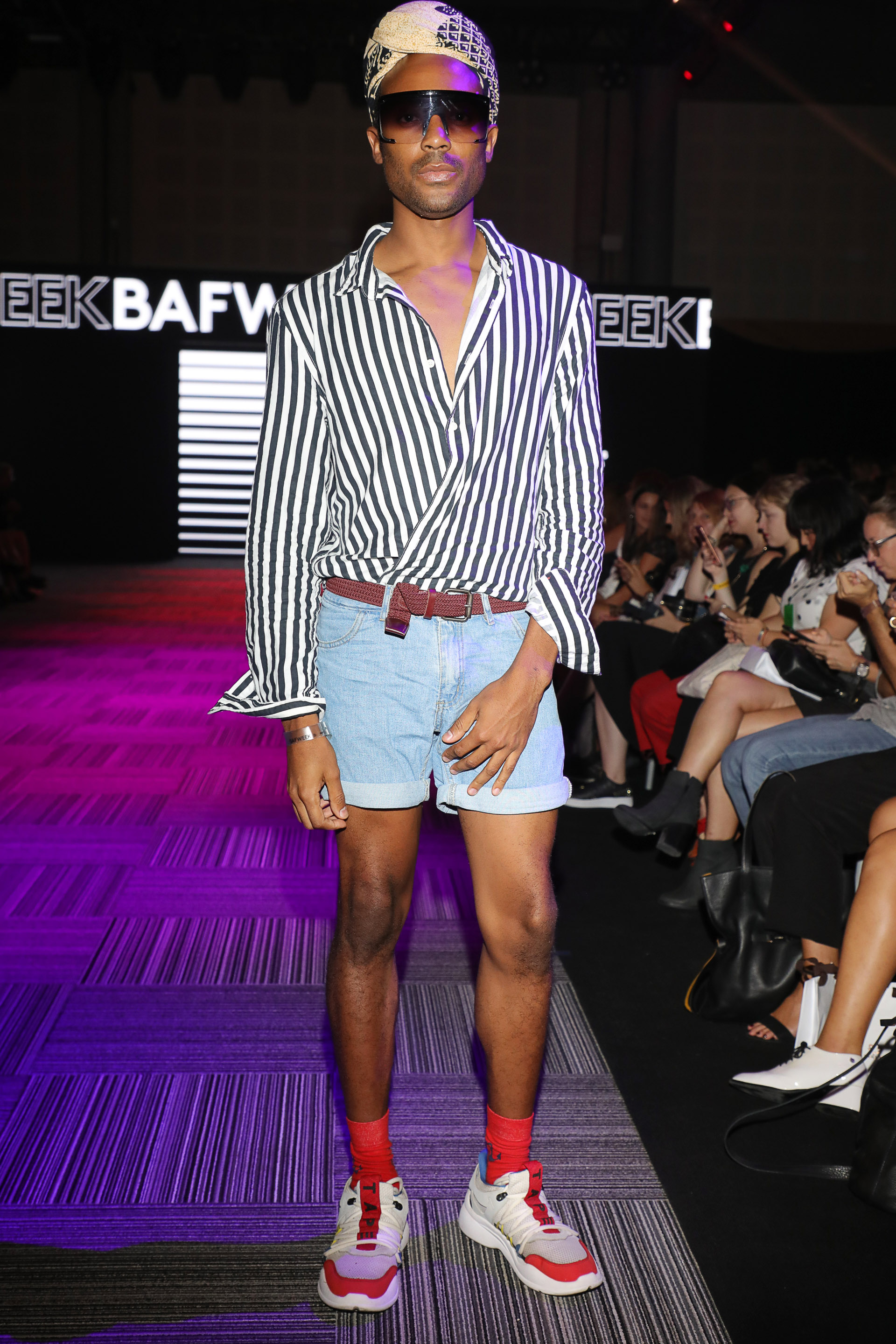 Camisa clásica, bermuda denim que se potencian con turbate en la cabeza y las sneakers del momento