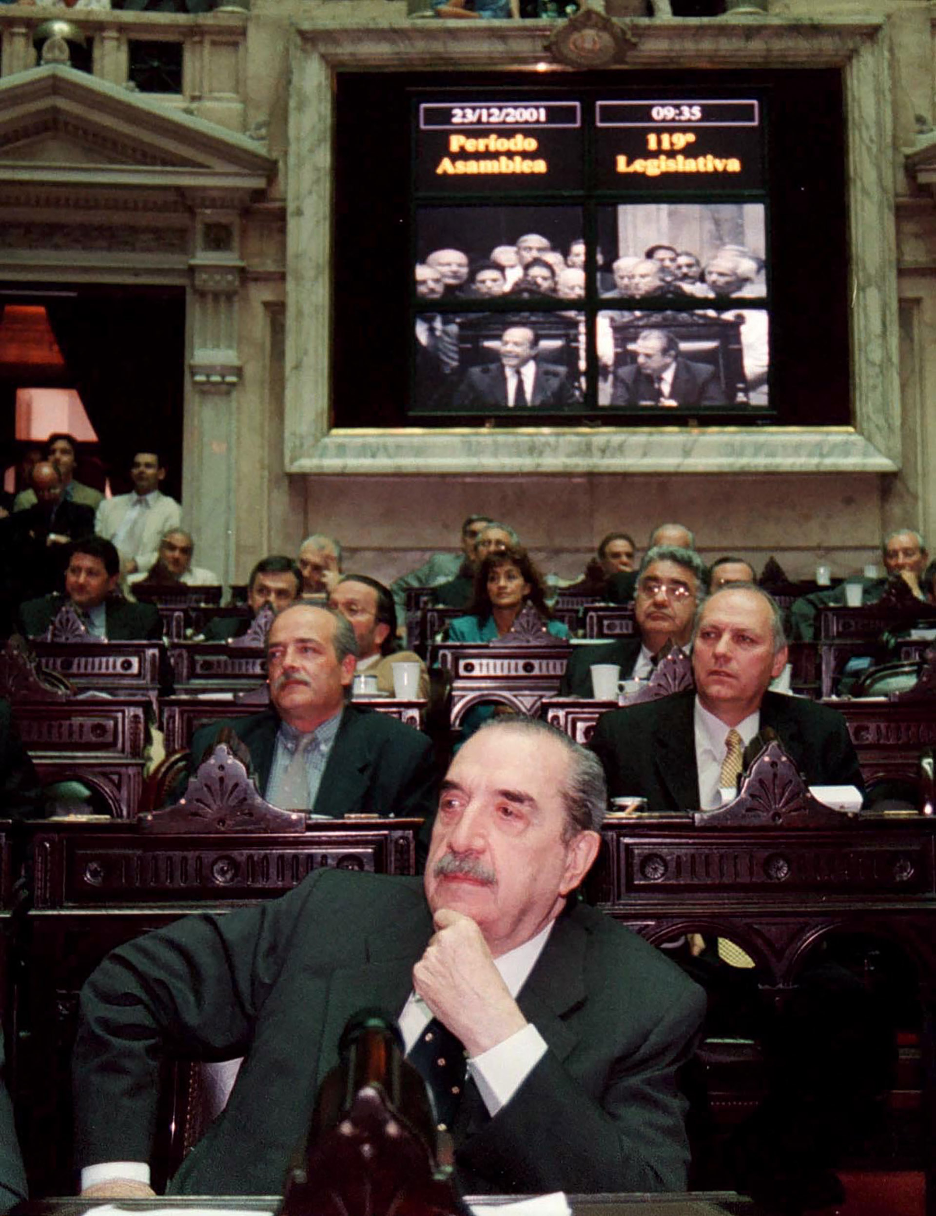 A fines de 2001 ex presidente escucha los anuncios del flamante presidente, Adolfo Rodríguez Saá, luego de la ceremonia de juramento realizada en el recinto del Congreso