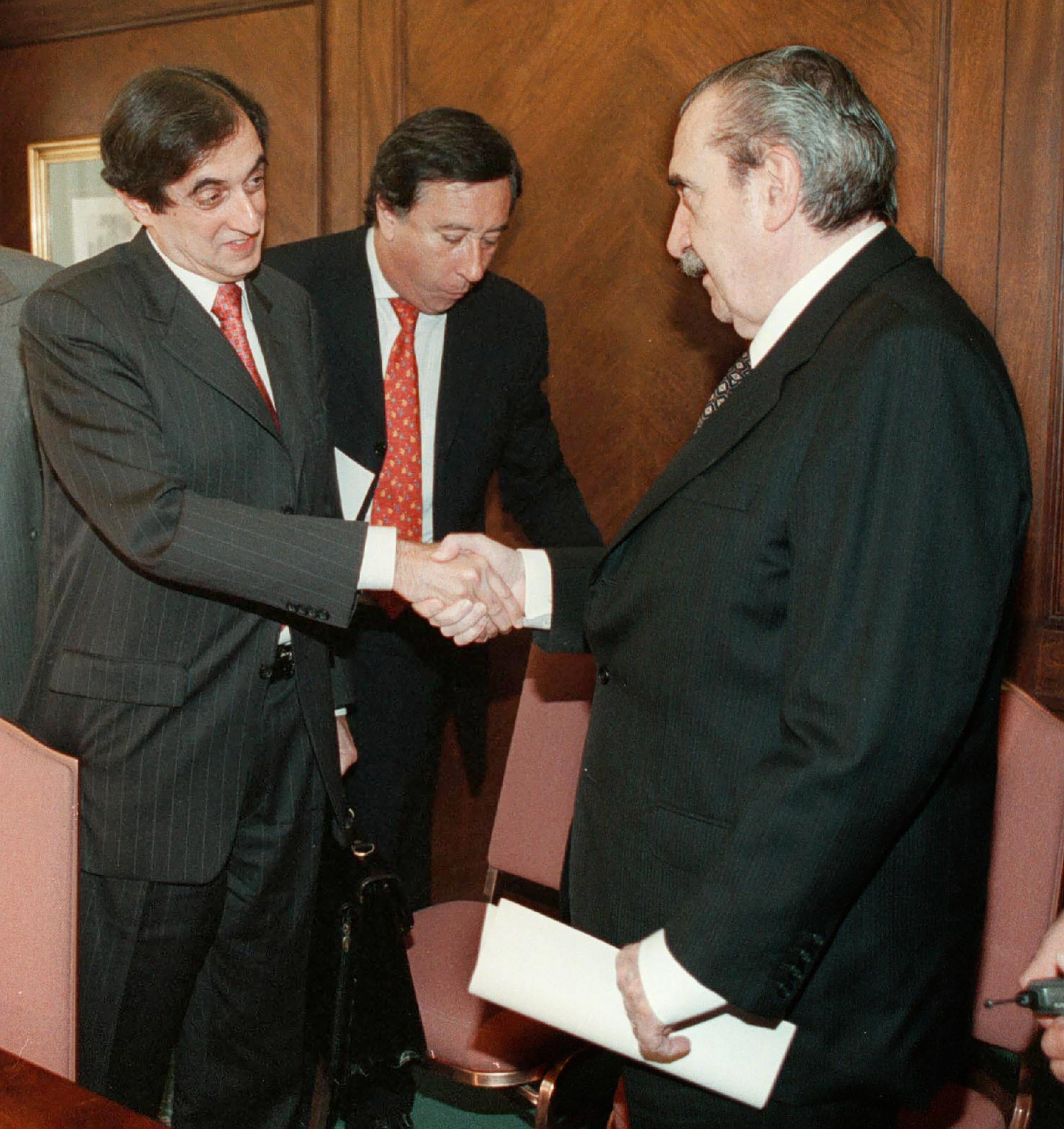 Alfonsín, como senador, le da la mano al representante del Fondo Monetario Internacional, Anoop Singh, luego de una reunión mantenida en un hotel internacional del barrio porteño de Retiro