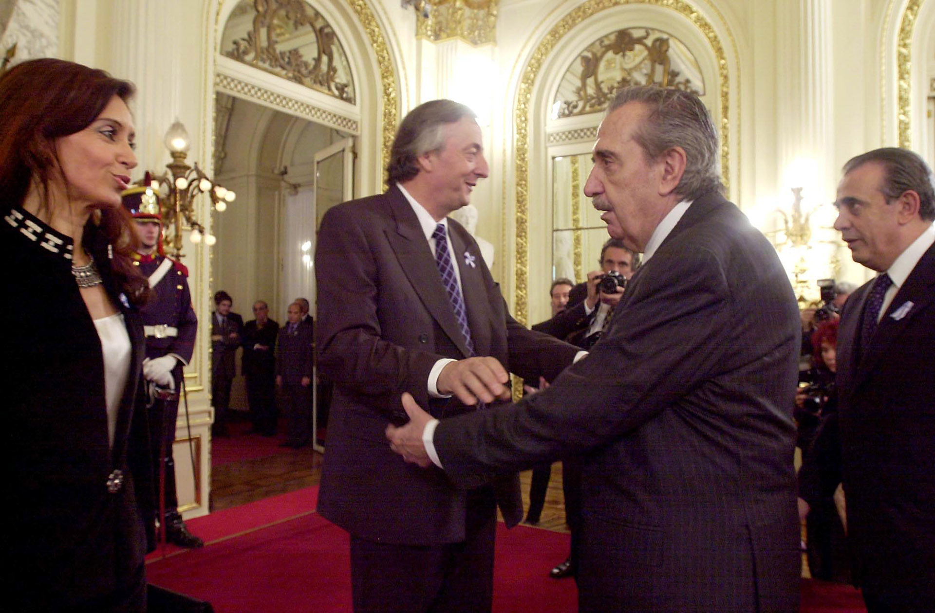 El ex mandatario saluda al entonces presidente Néstor Kirchner y su esposa Cristina Fernandez en la Casa de Gobierno