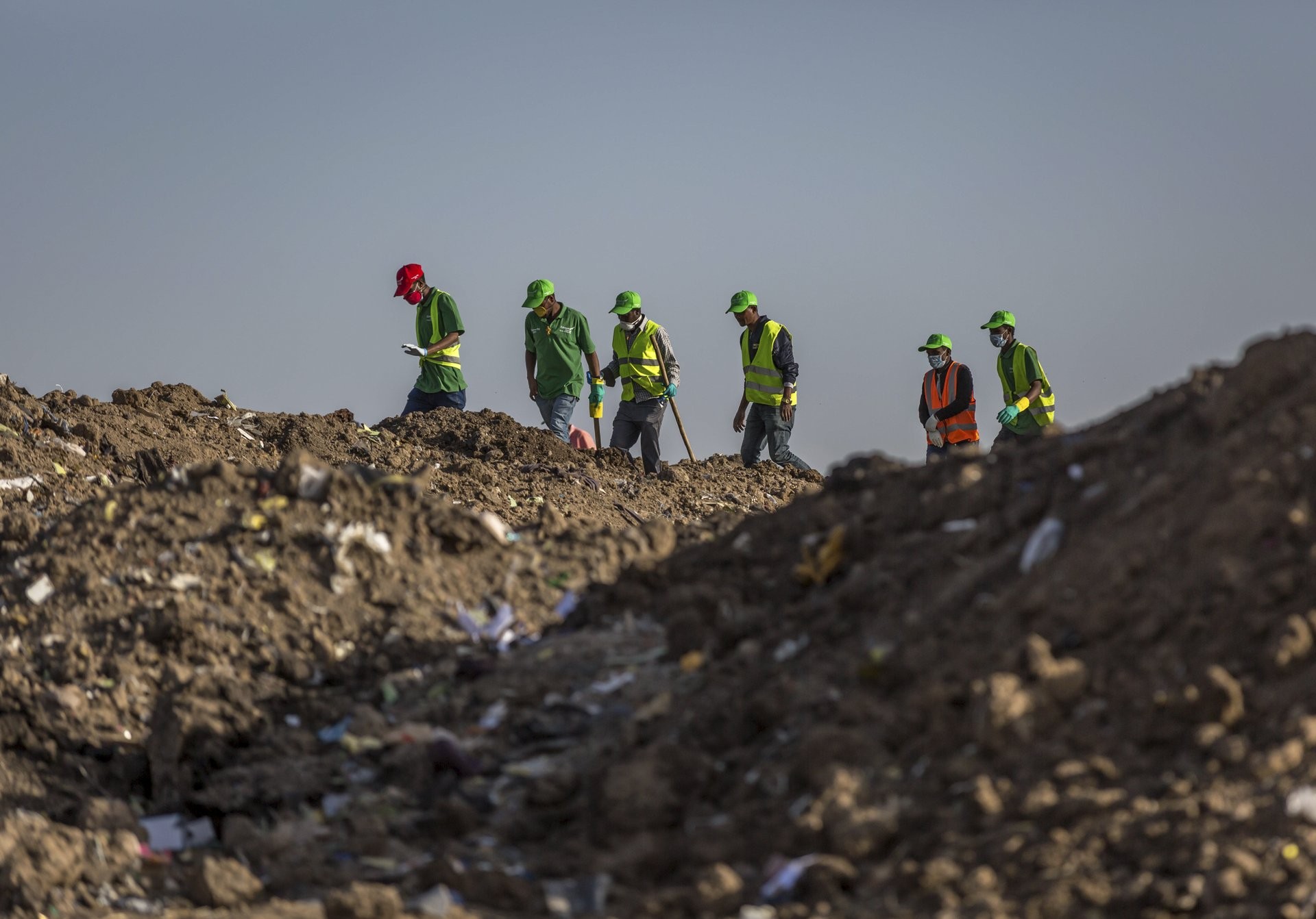 Trabajadores recolectan ropa y otros materiales, bajo la instrucción de los investigadores, en el lugar donde se desplomó el Boeing 737 Max 8 (Foto: AP)