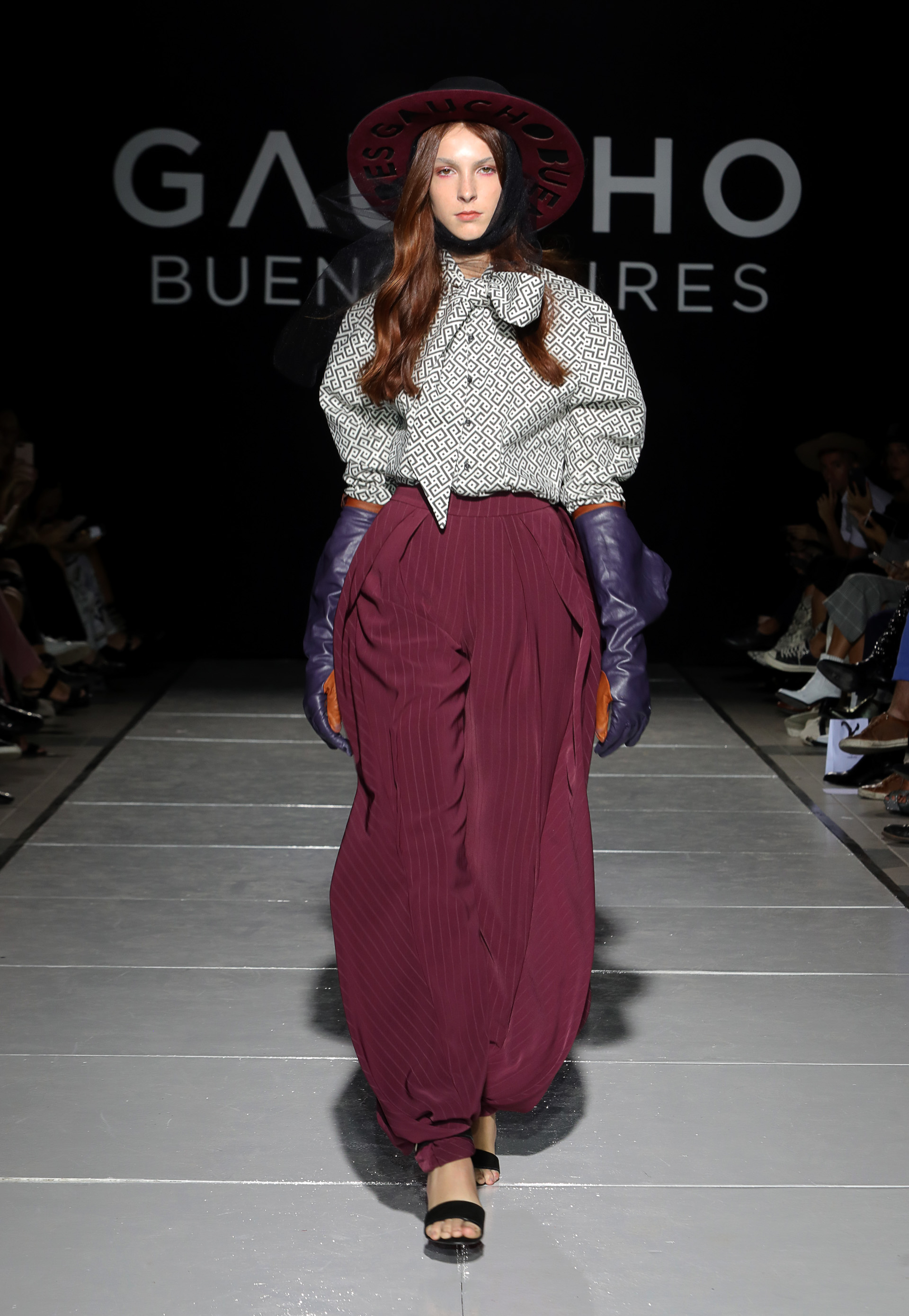 La sastería fue el gran fuerte de Gaucho. Los pantalones, en varios cortes. El babucha fue presentado en borravino, cintura alta y con pequeñas líneas blancas, completando el look con guantes de cuero bicolor naranjas y violetas y una camisa sastrera con estampada geométrico