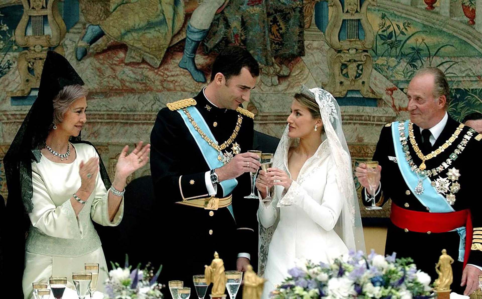 Spanish Crown Prince Felipe (2nd L) and his bride Letizia Ortiz, Princess of Asturias, (CR) toast as King Juan Carlos (R) and Queen Sofia look on at the start of their wedding banquet at Madrid's Royal Palace May 22, 2004. [Prince Felipe married former television presenter Ortiz in a glittering ceremony symbolising a new dawn for Spain two months after the deadly Madrid train bombings.]