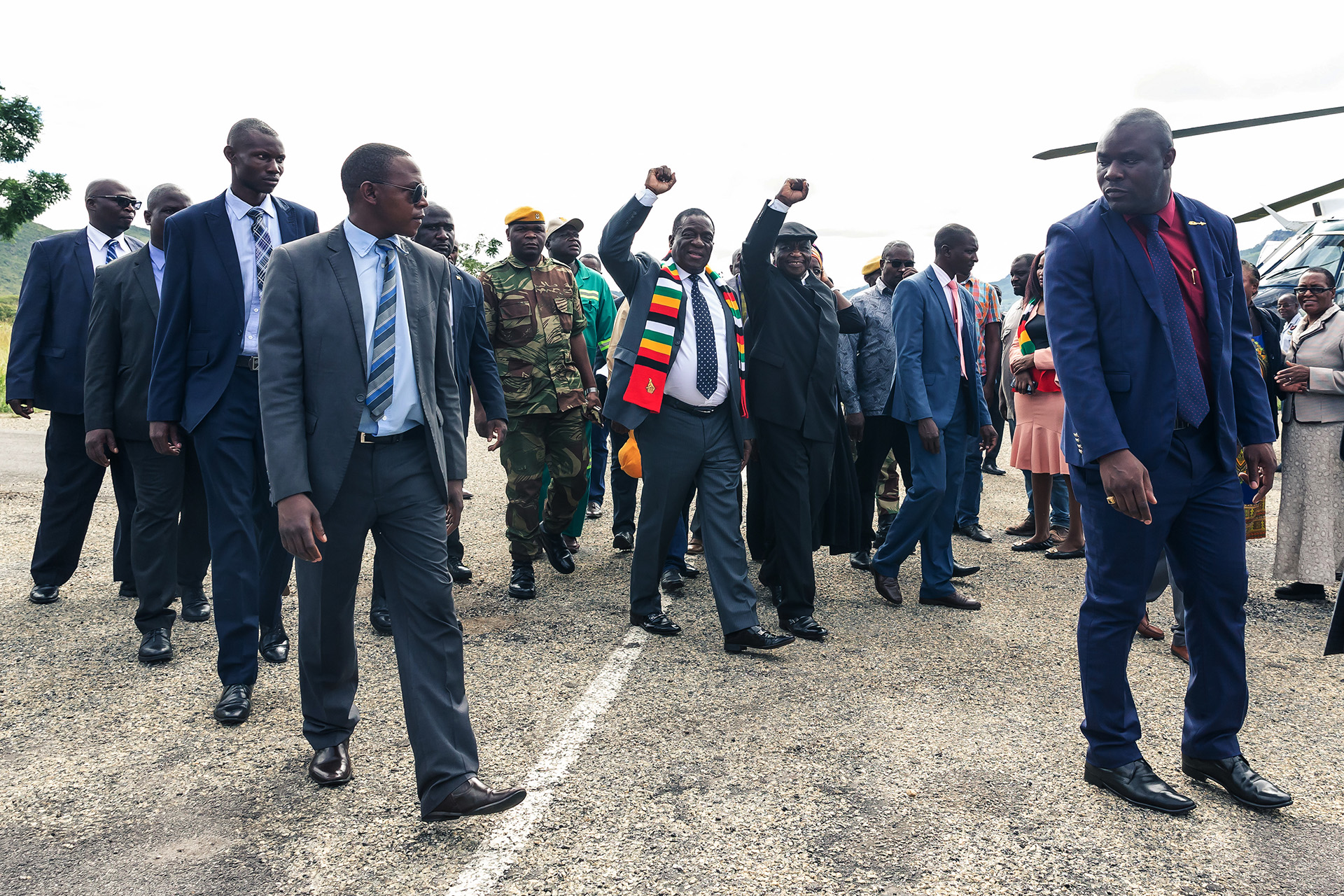 El presidente zimbabuense Emmerson Mnangagwa (L) saluda a partidarios con su vicepresidente Constantino Chiwenga (R) a su llegada a Mutare, provincia de Manicaland, antes de recorrer las áreas devastadas por el ciclón Idai en Chimanimani, el 19 de marzo. (Photo by Jekesai NJIKIZANA / AFP)