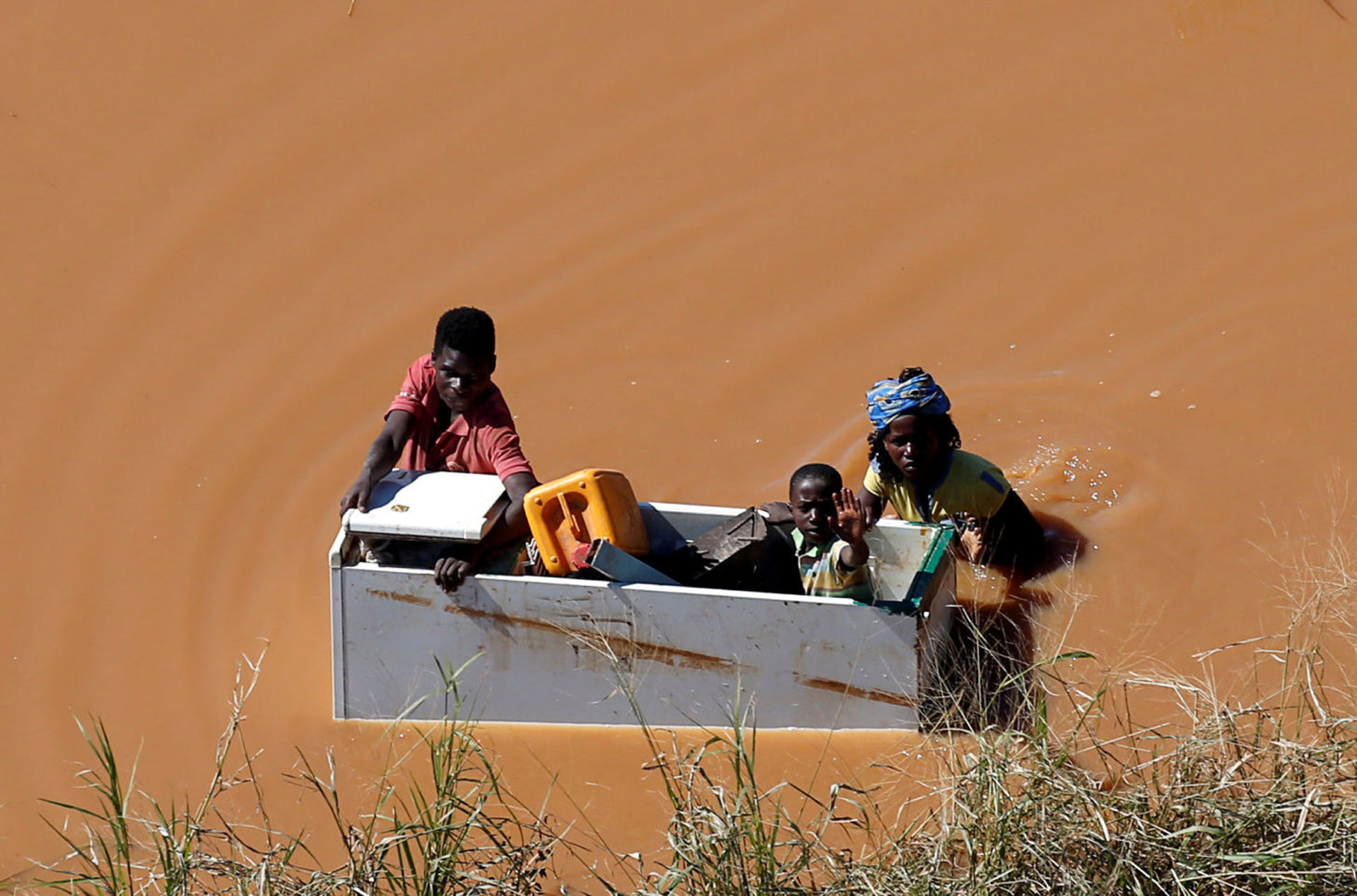 Un niño es transportado por sus padres en un refrigerador en Buzi, una zona inundada en las afueras de Beira, tras el paso del ciclón Idai (Foto: REUTERS/Siphiwe Sibeko)